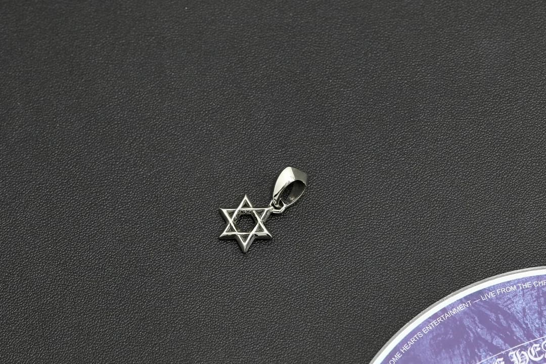 Крупный план гравировки на серебряной подвеске Chrome Hearts