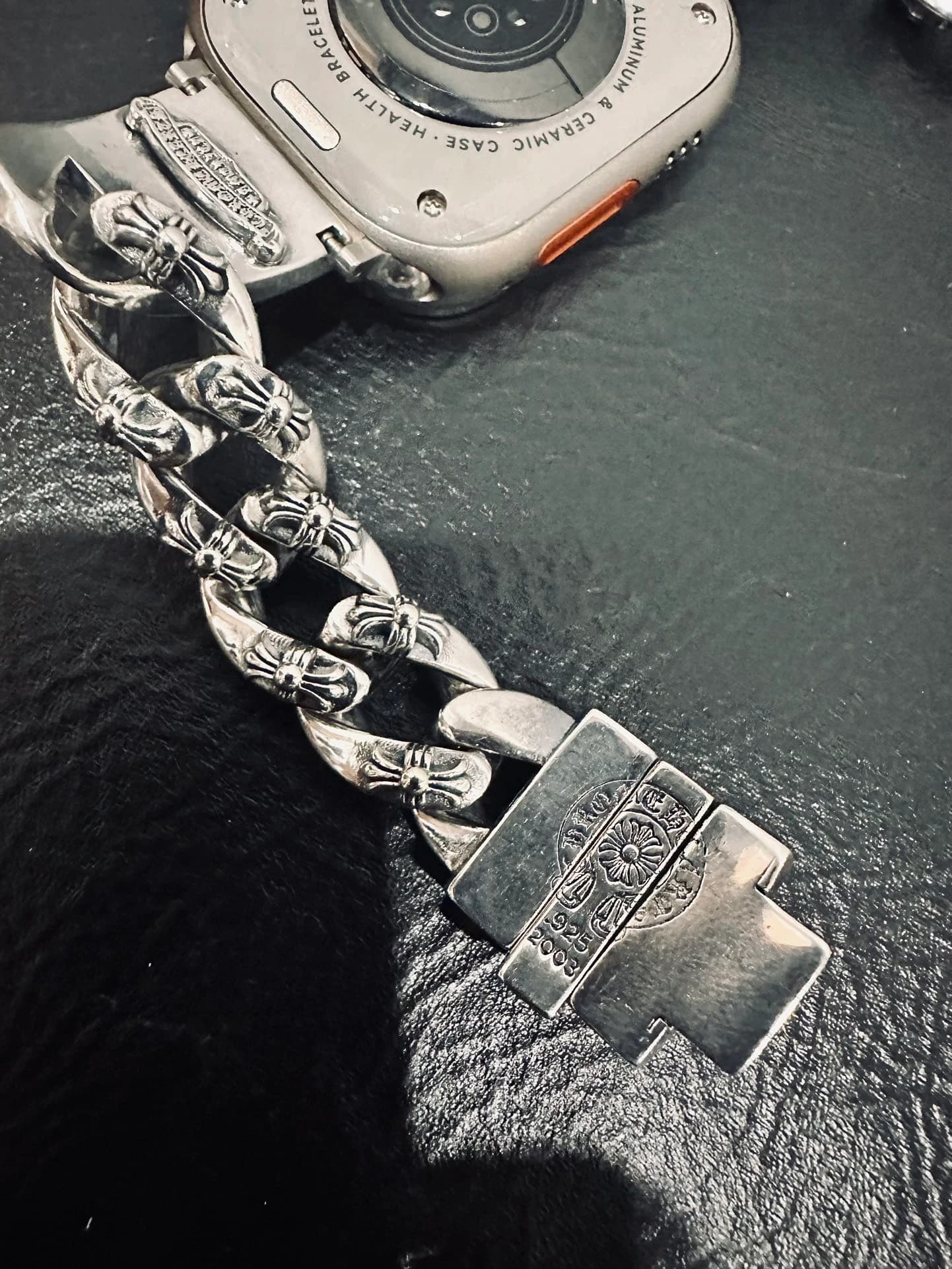 Крупный план серебряных звеньев и застежки с гравировкой Chrome Hearts
