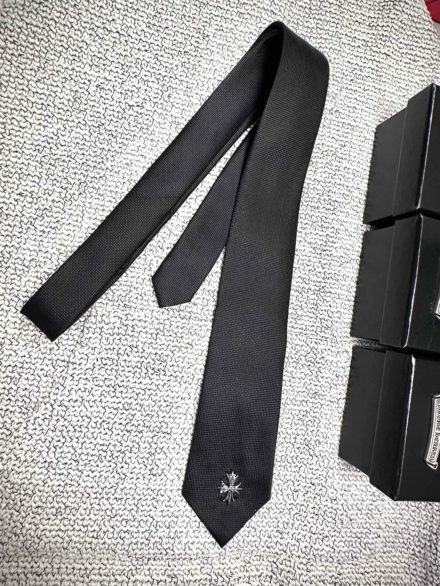 Чёрный галстук Chrome Hearts рядом с подарочными коробками