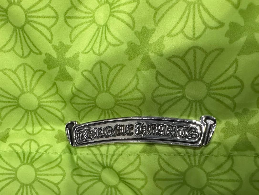 Металлическая пластина с логотипом Chrome Hearts на зеленом жилете