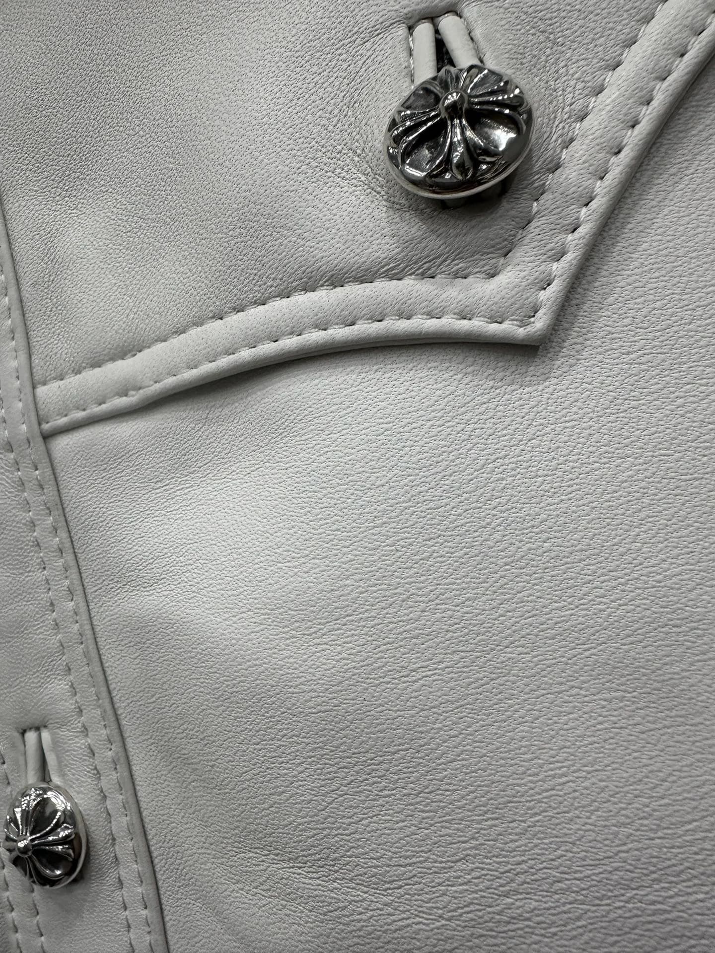 Деталь кармана и металлической пуговицы с крестом на куртке Chrome Hearts