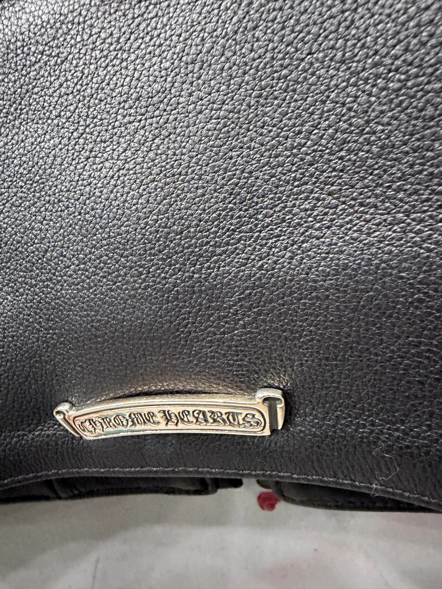 Серебряная пластина с логотипом Chrome Hearts на куртке