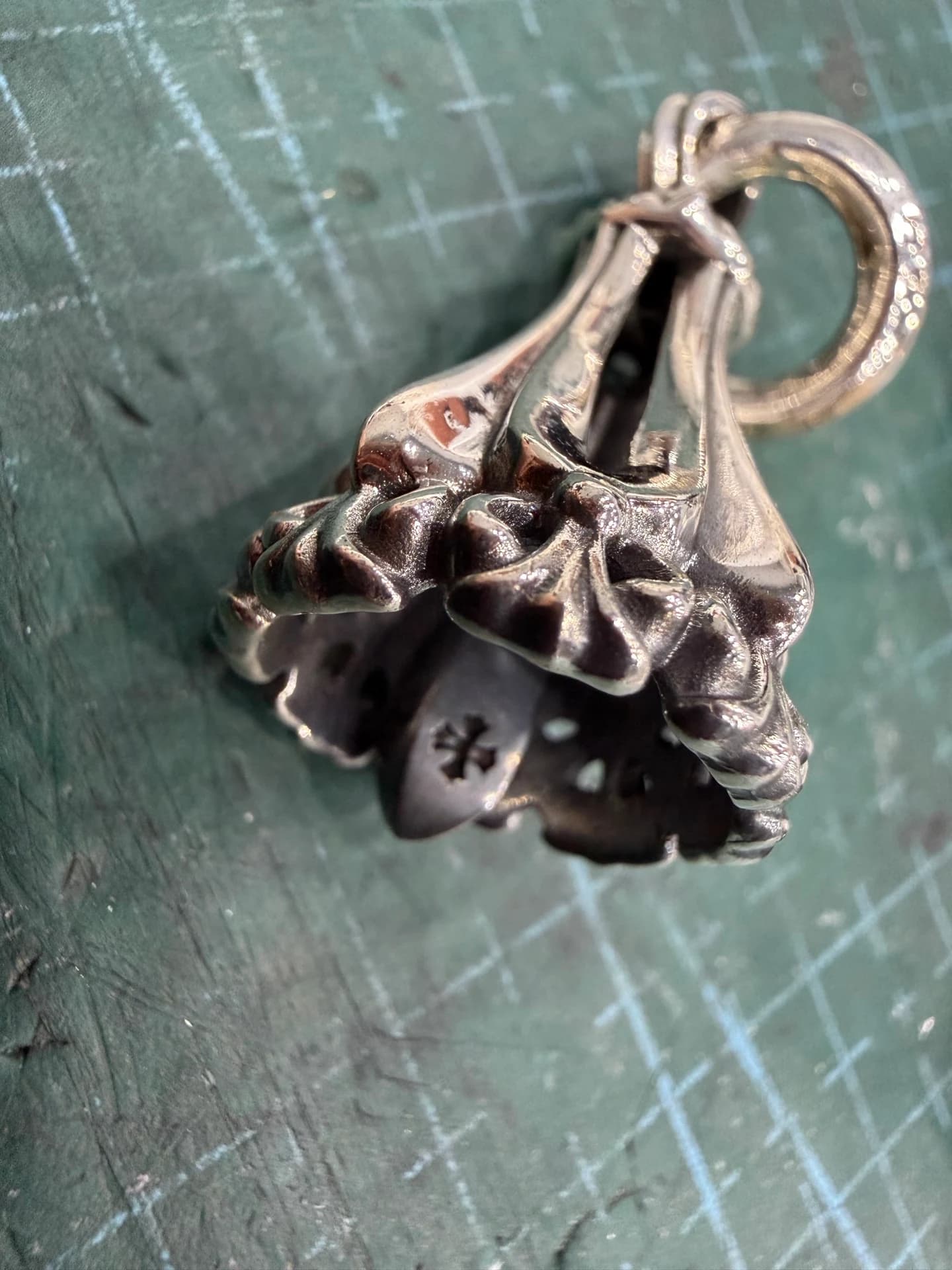 Нижняя часть подвески Chrome Hearts Bell с язычком и гравировкой креста крупным планом