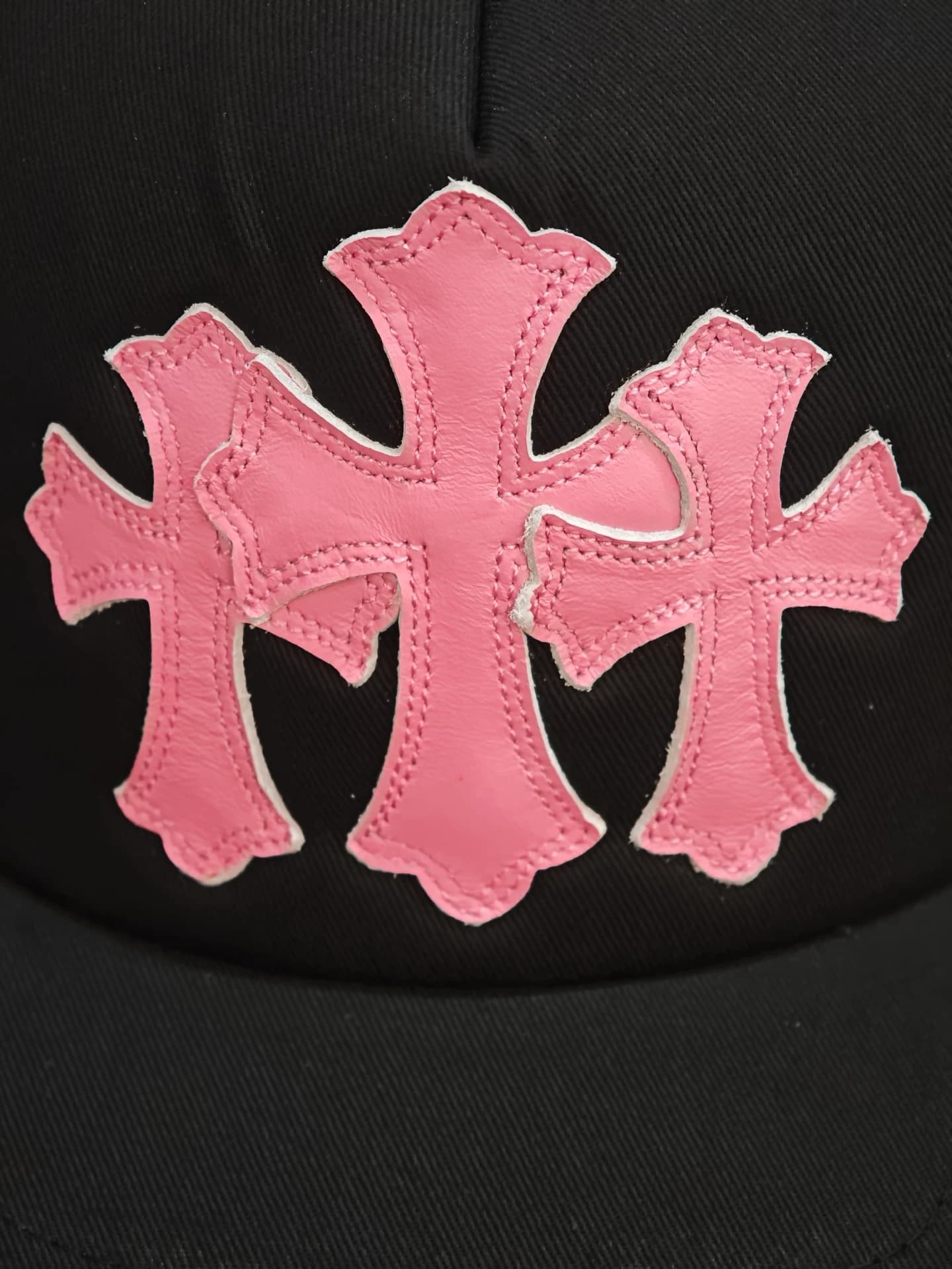 Деталь черной бейсболки Chrome Hearts с розовыми кожаными патчами