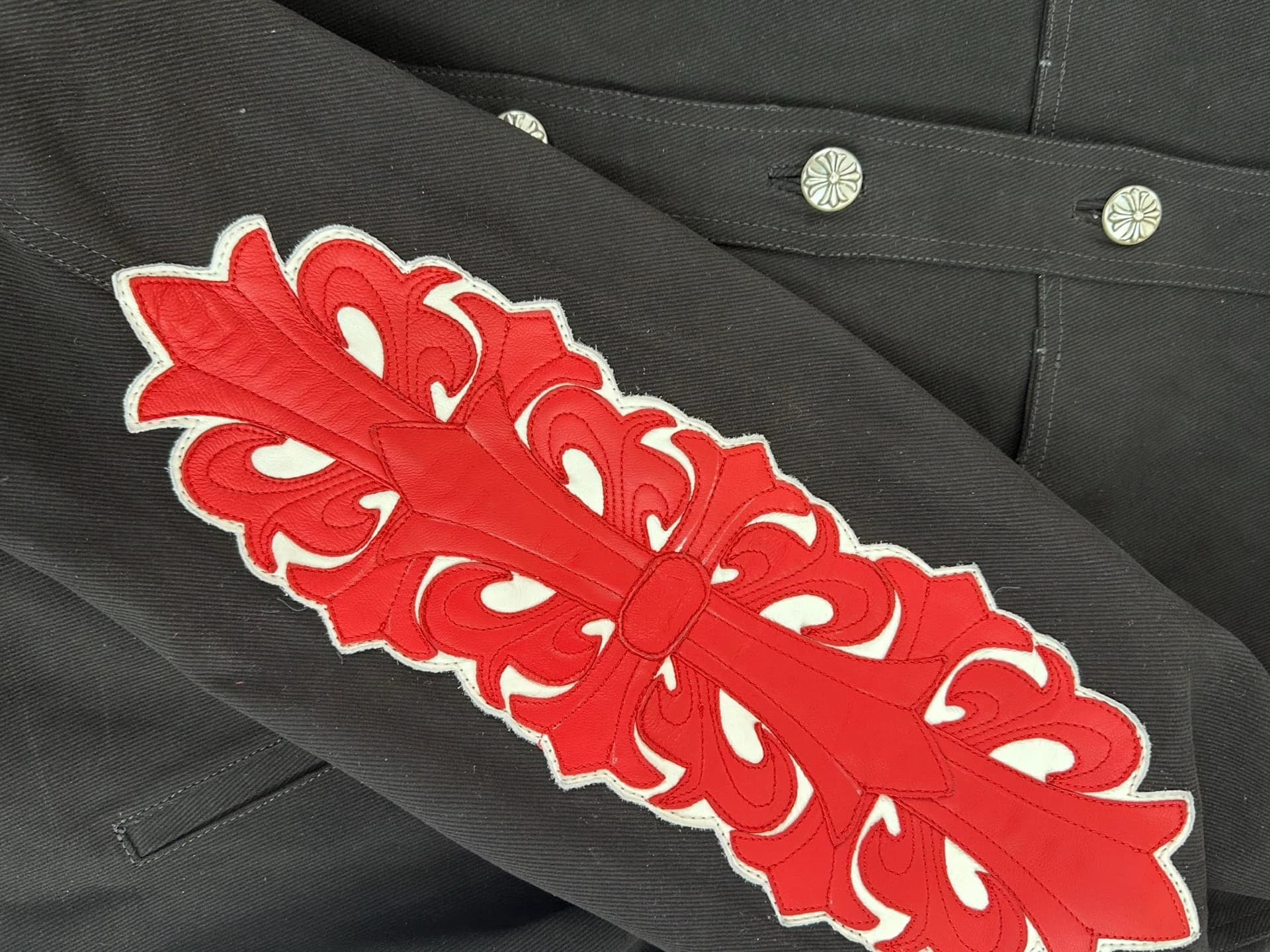 Рукав джинсовой куртки Chrome Hearts с красно-белой нашивкой