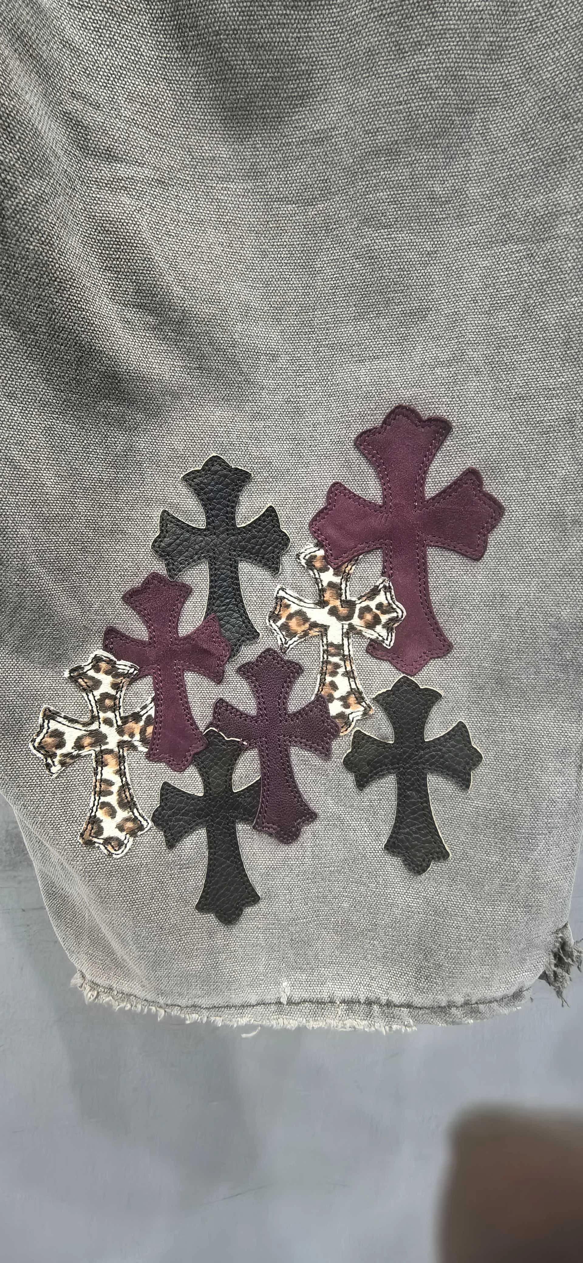 Деталь низа штанины с нашивками на джинсах Chrome Hearts x Carhartt B12