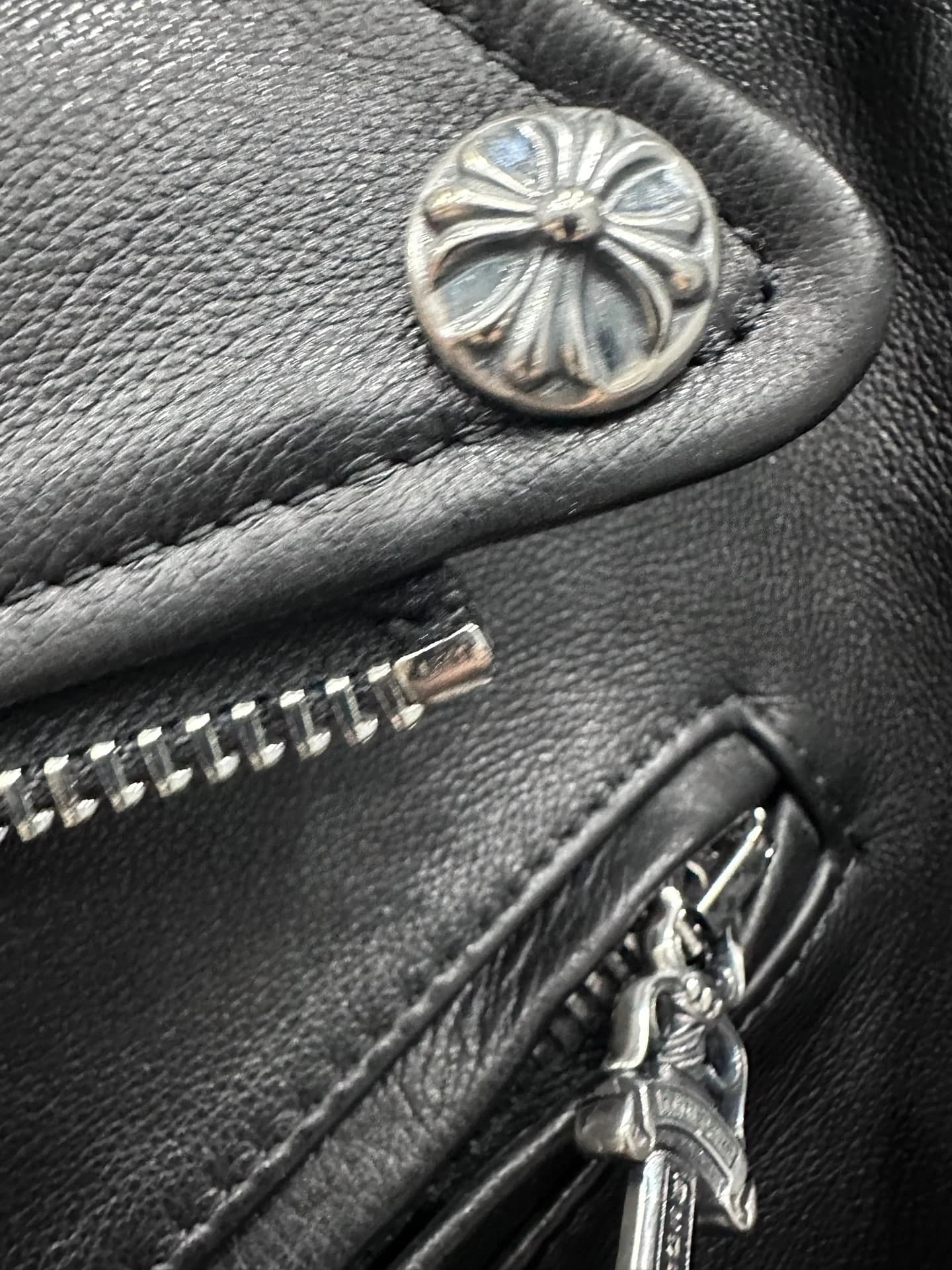 Серебряная кнопка с крестом и молния на куртке Chrome Hearts