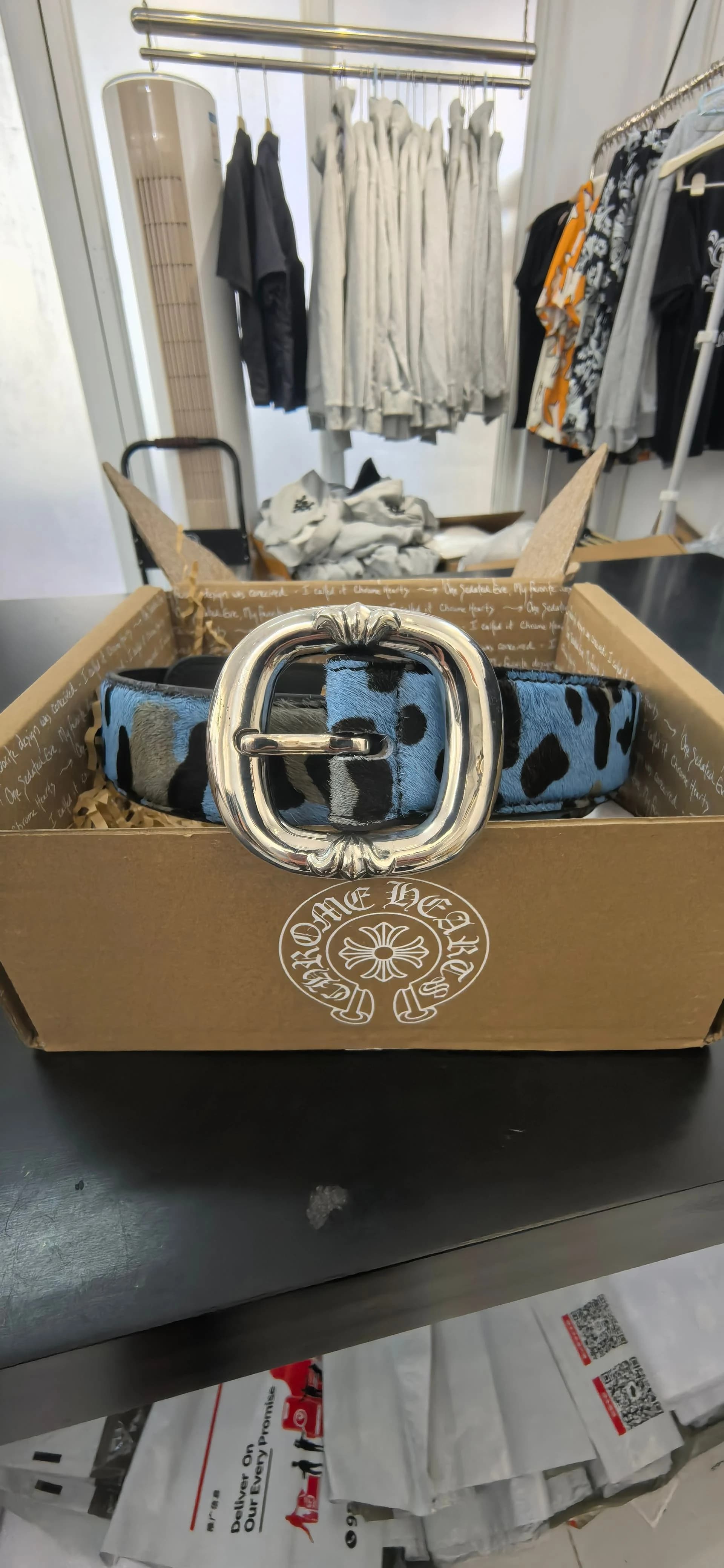 Овальная пряжка ремня Chrome Hearts на фоне открытой коробки
