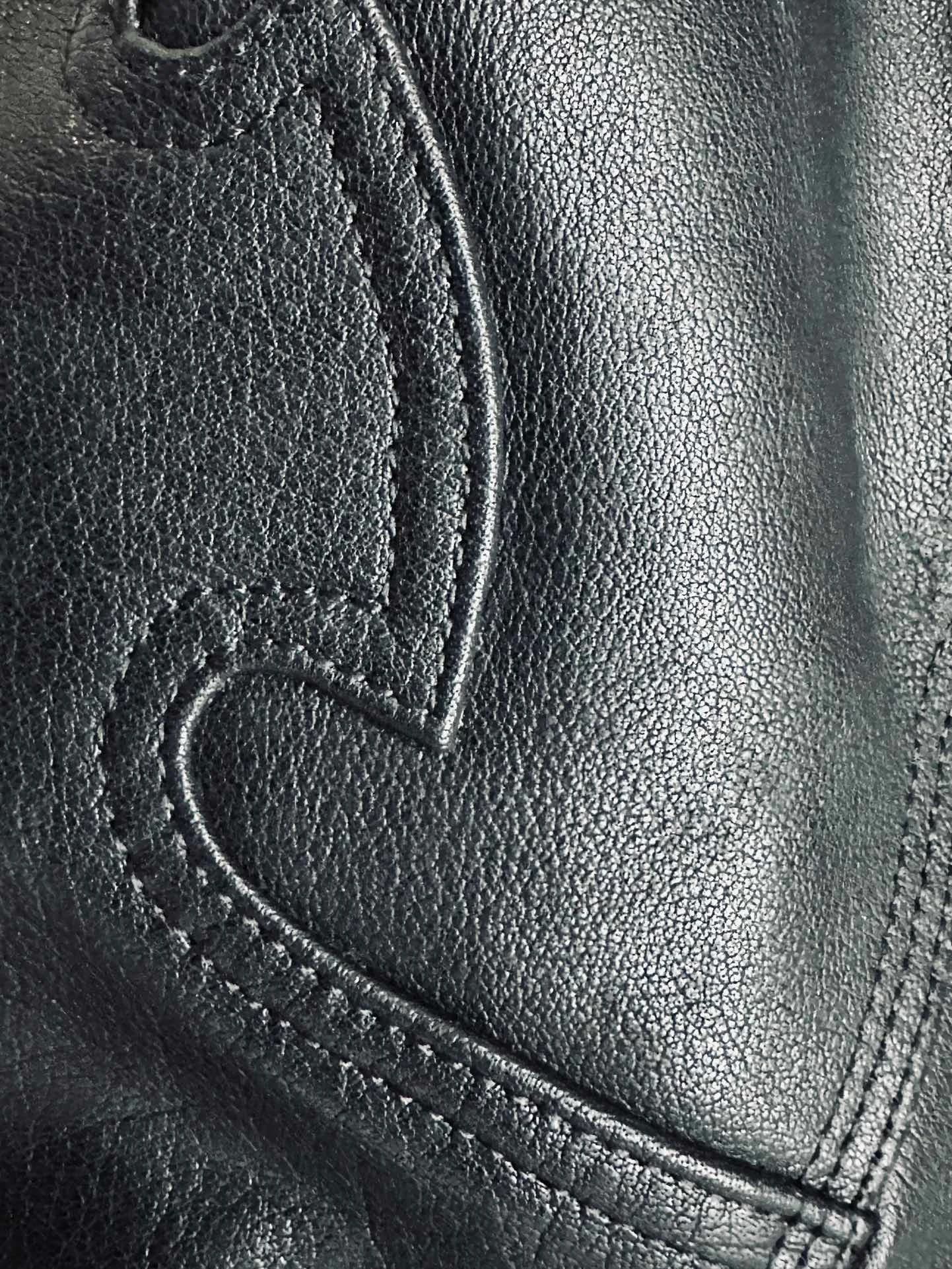 Крупный план кожаной нашивки в виде пламени на брюках Chrome Hearts