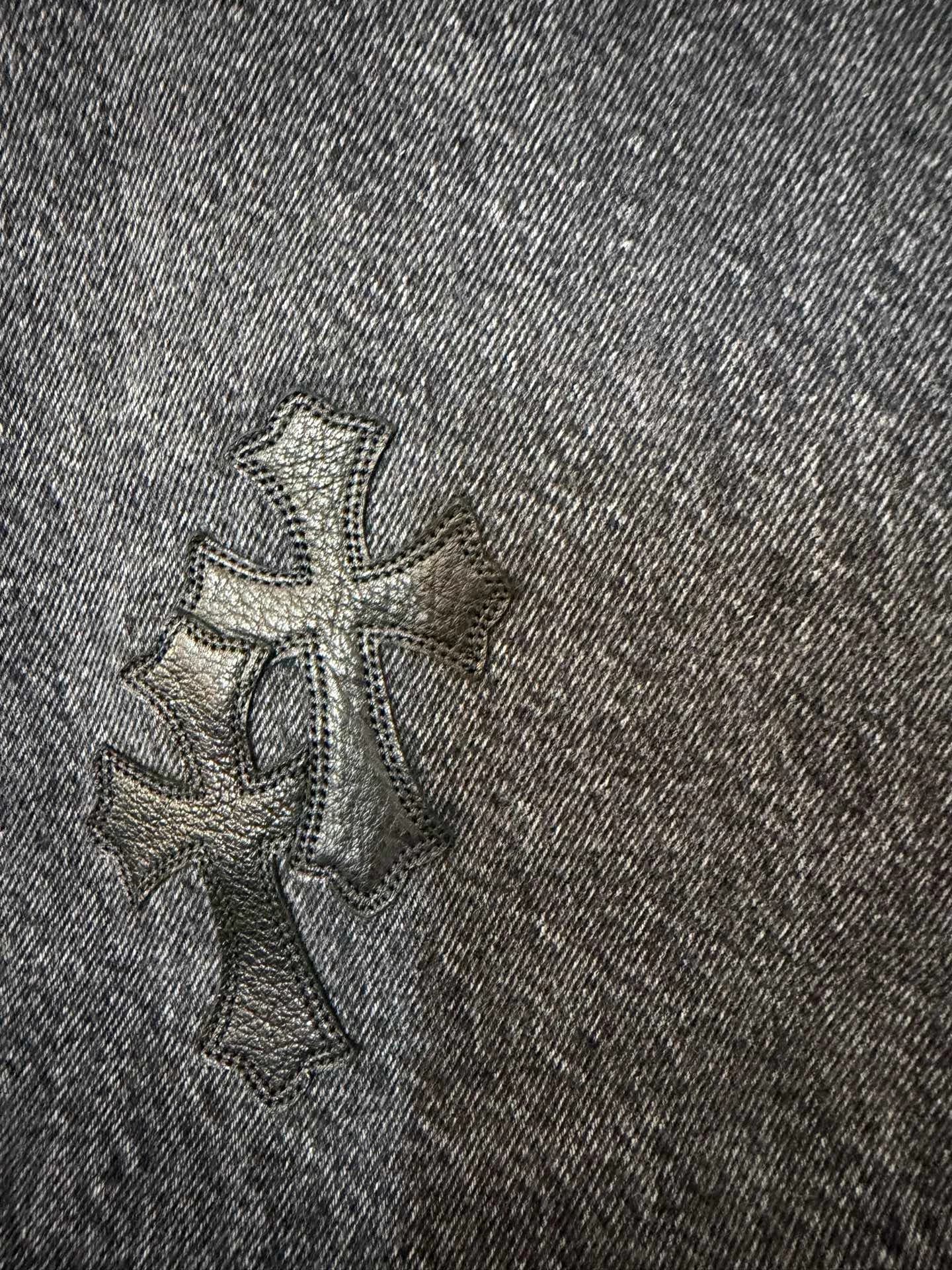 Деталь кожаной нашивки в виде креста на джинсах Chrome Hearts