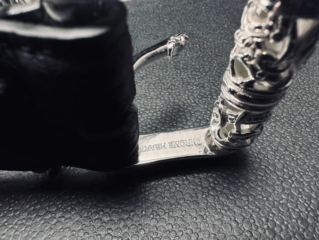 Детали металлической серебряной фурнитуры ремня Chrome Hearts с гравировкой
