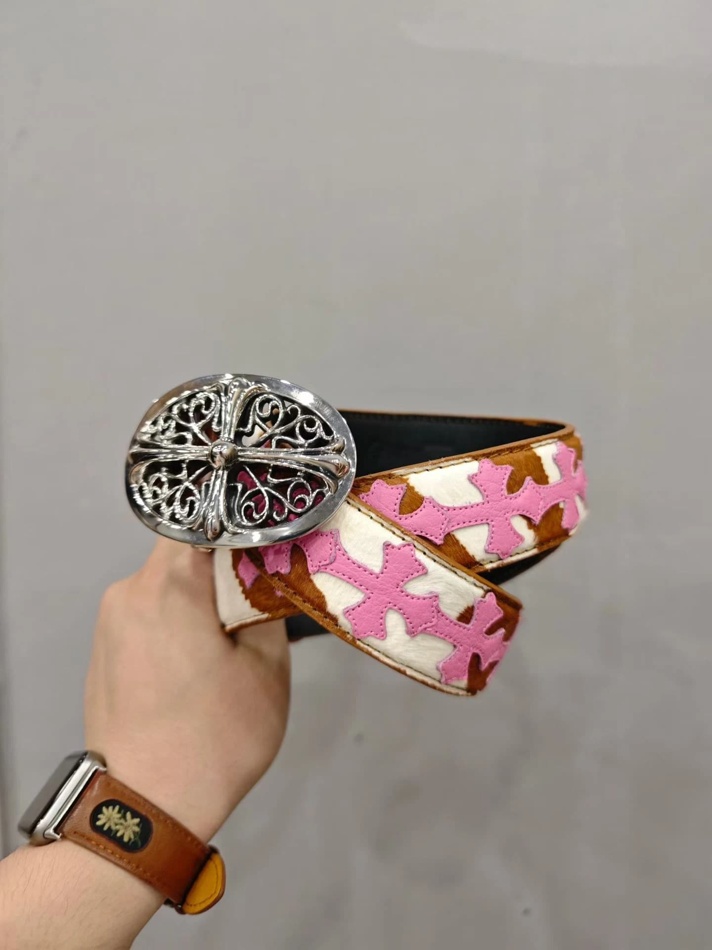 Ремень Chrome Hearts с овальной серебряной пряжкой в руке