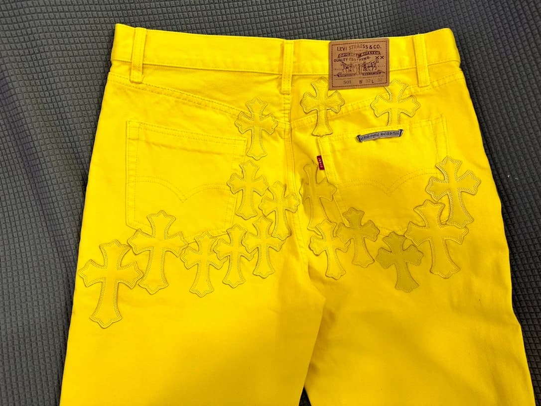 Детали задней части желтых джинсов Chrome Hearts x Levi's с нашивками-крестами