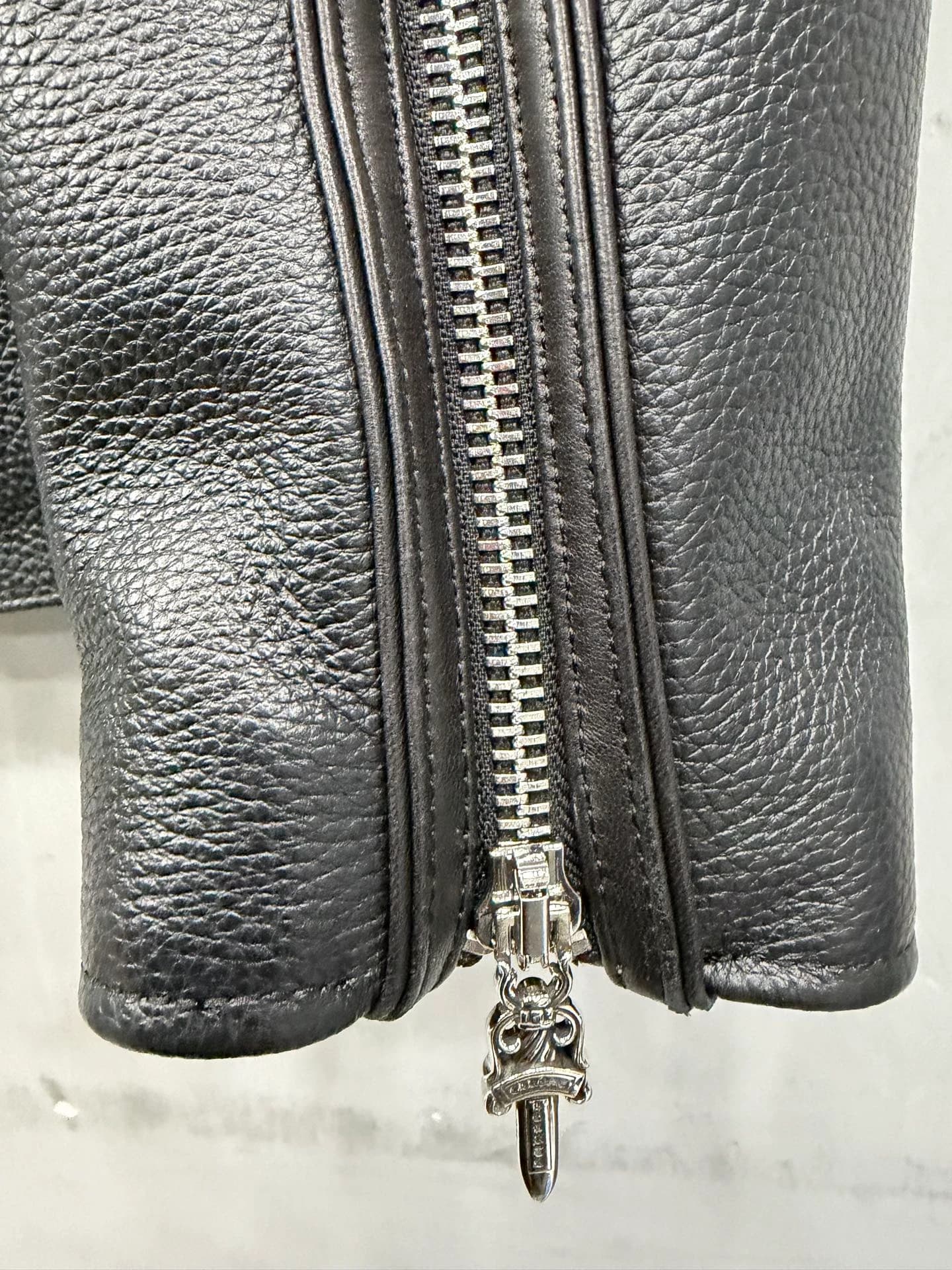 Деталь молнии на рукаве куртки Chrome Hearts с пуллером-кинжалом