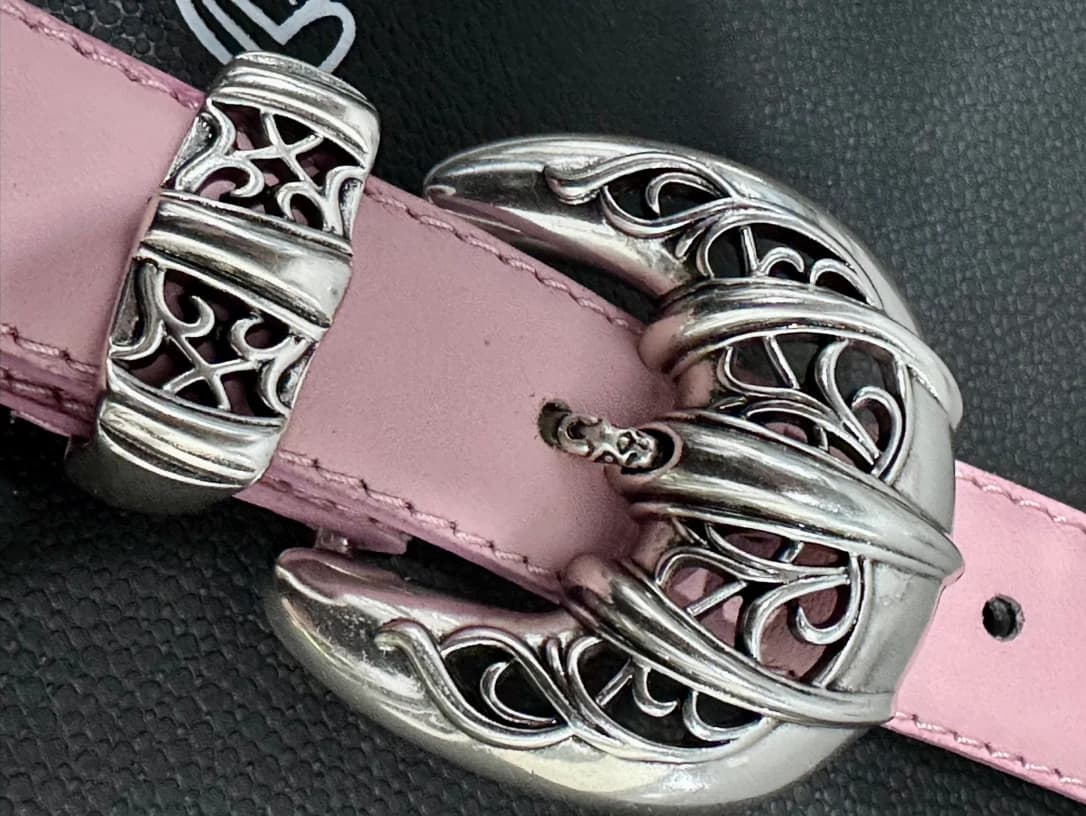 Резная серебряная пряжка на розовом кожаном ремне Chrome Hearts крупным планом