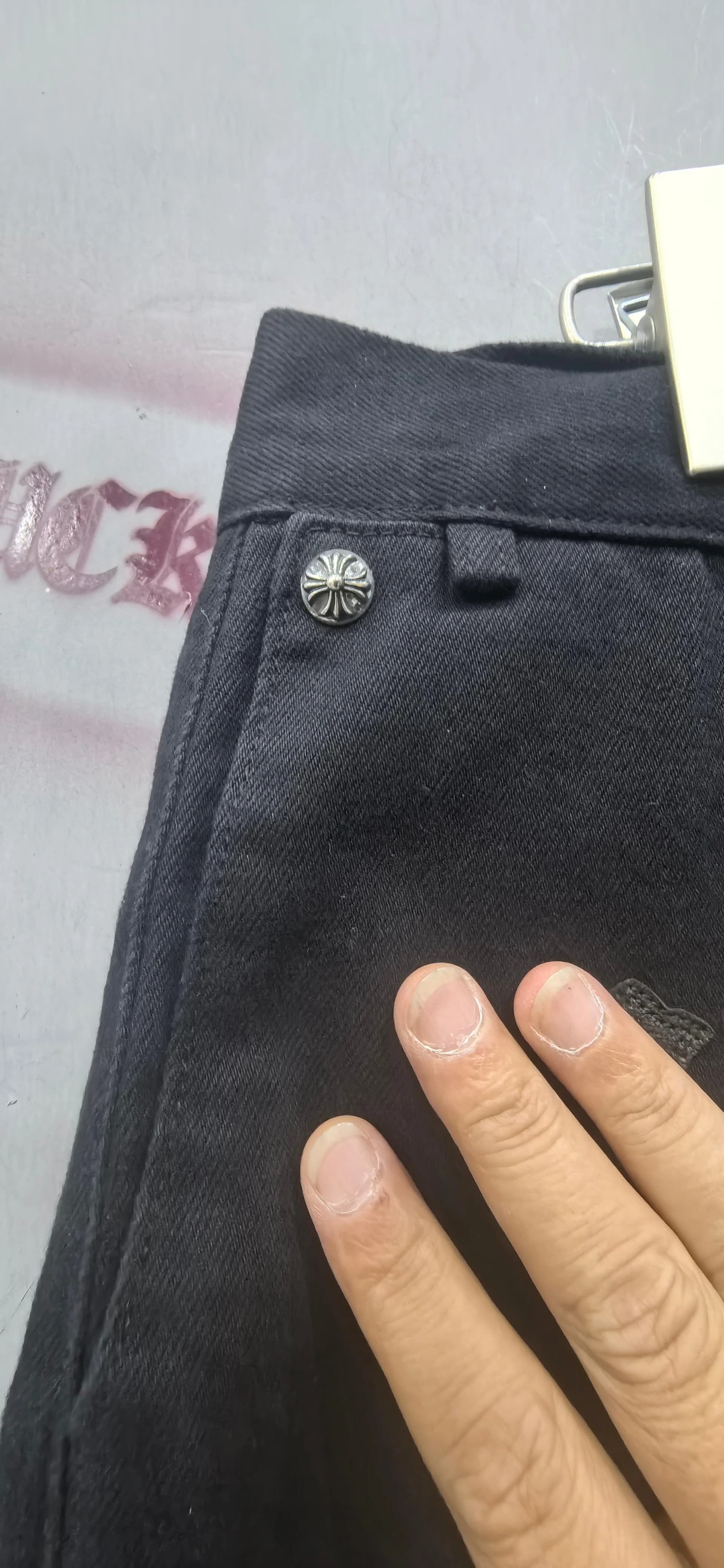 Деталь пояса и металлическая пуговица брюк Chrome Hearts