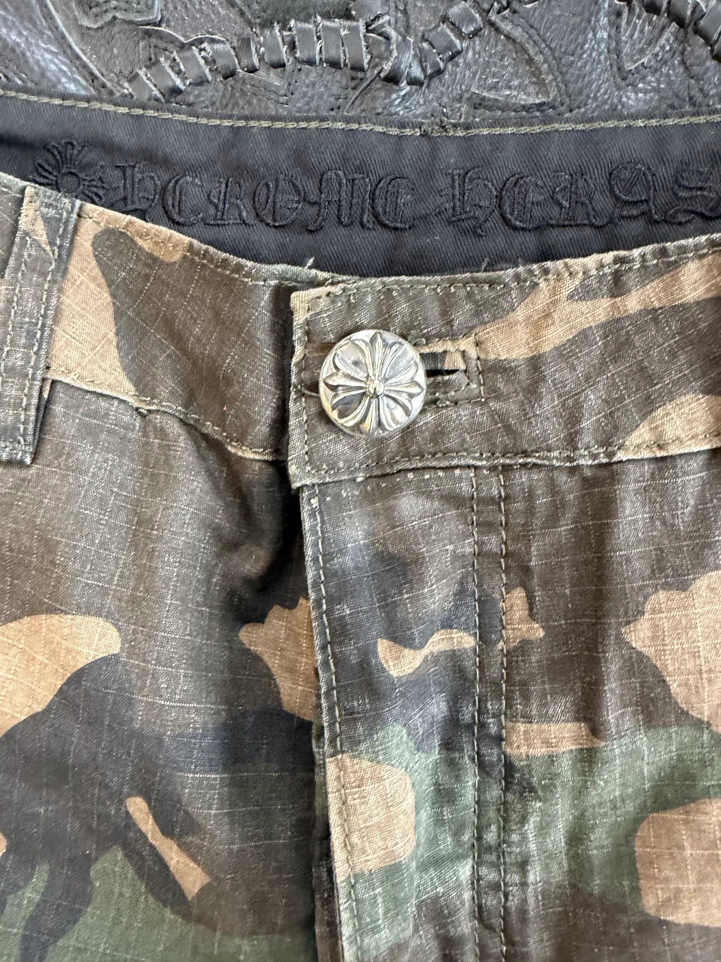Деталь пояса шорт Chrome Hearts с серебряной пуговицей-крестом