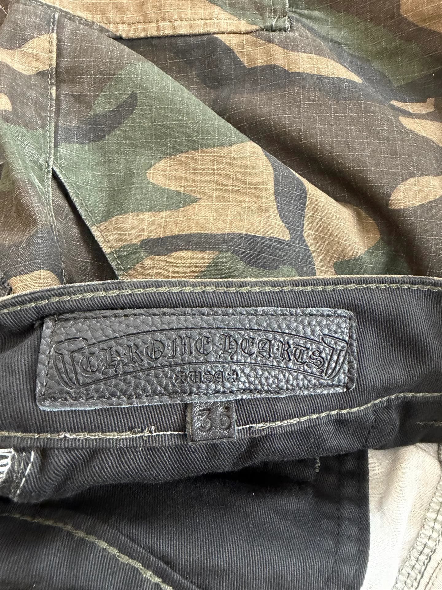 Кожаная нашивка с тиснением бренда на внутренней стороне пояса шорт Chrome Hearts