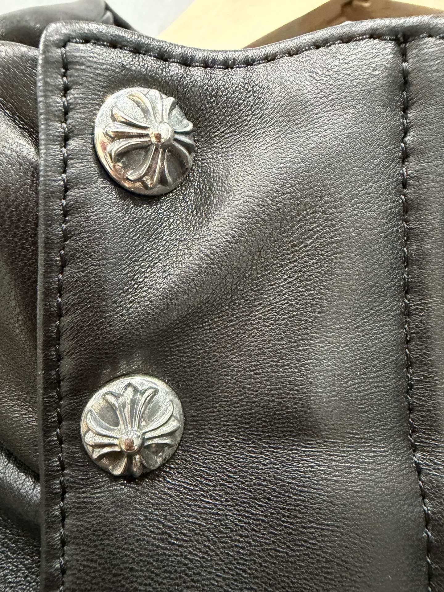 Кнопки в виде фирменных крестов Chrome Hearts на кожаном жилете