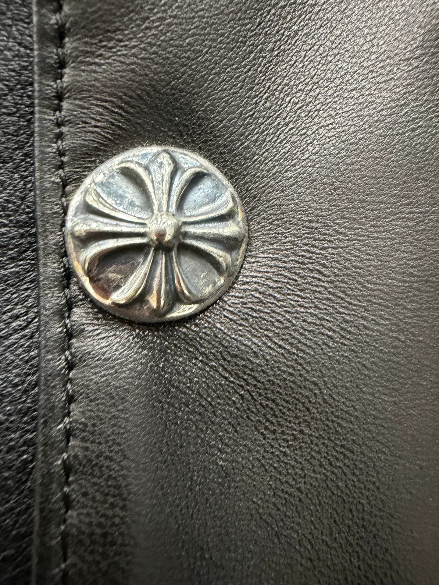 Крупный план серебряной кнопки-креста Chrome Hearts