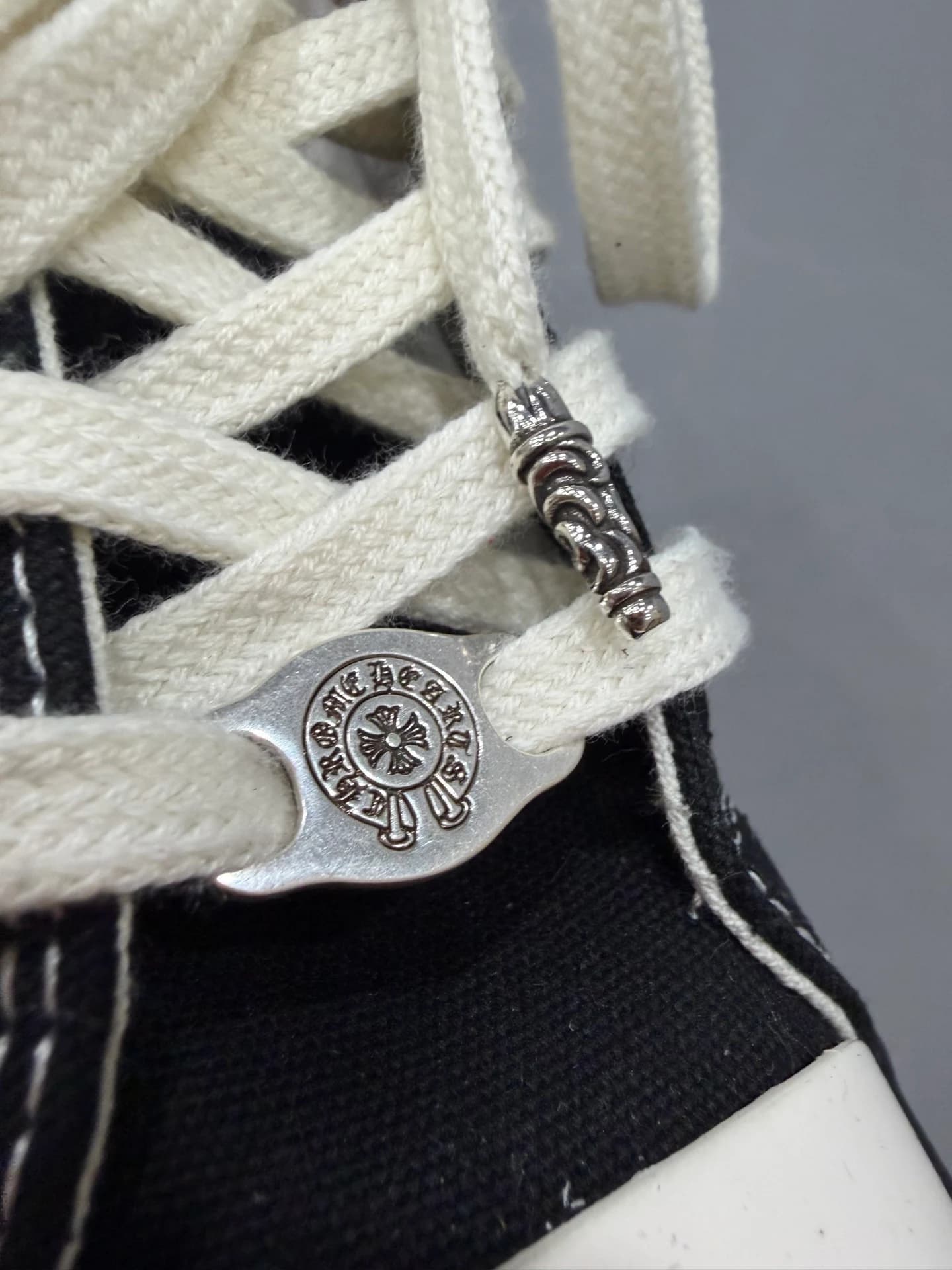 Деталь шнуровки кед Chrome Hearts x Converse с серебряной фурнитурой