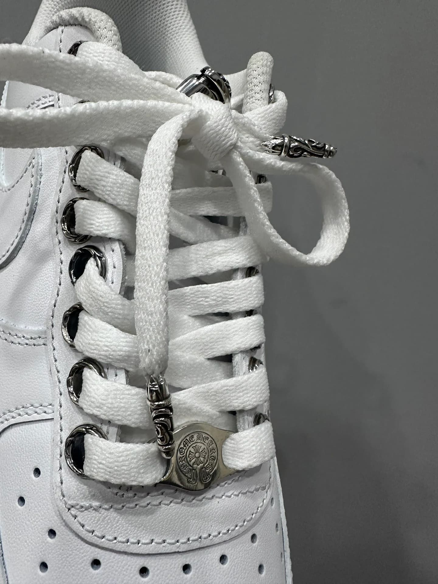 Детали шнуровки и серебряная фурнитура Chrome Hearts на кроссовках Nike Air Force 1