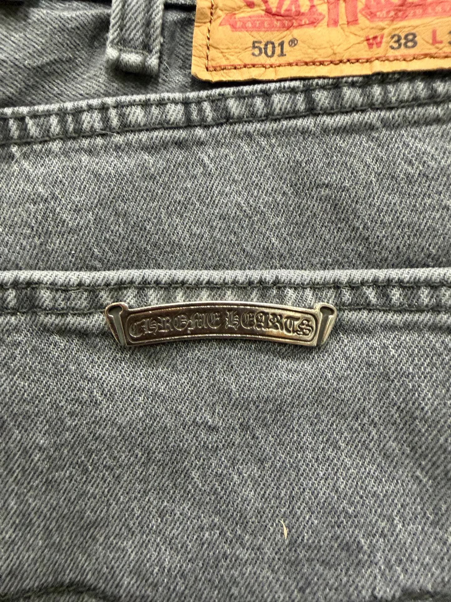 Крупный план металлической пластины Chrome Hearts и патча Levi's 501