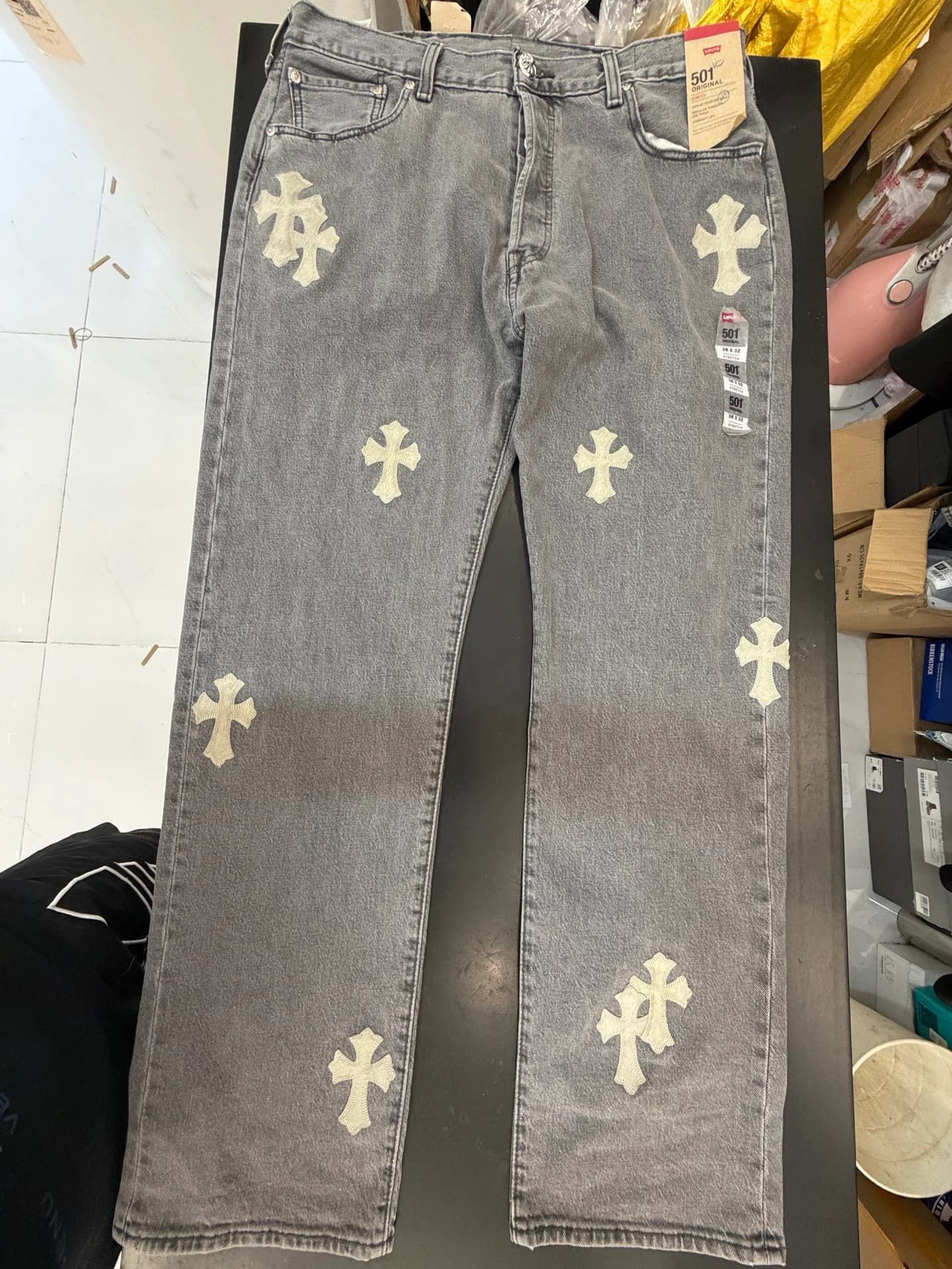 Серые джинсы Chrome Hearts x Levi's 501, разложенные на поверхности, вид спереди