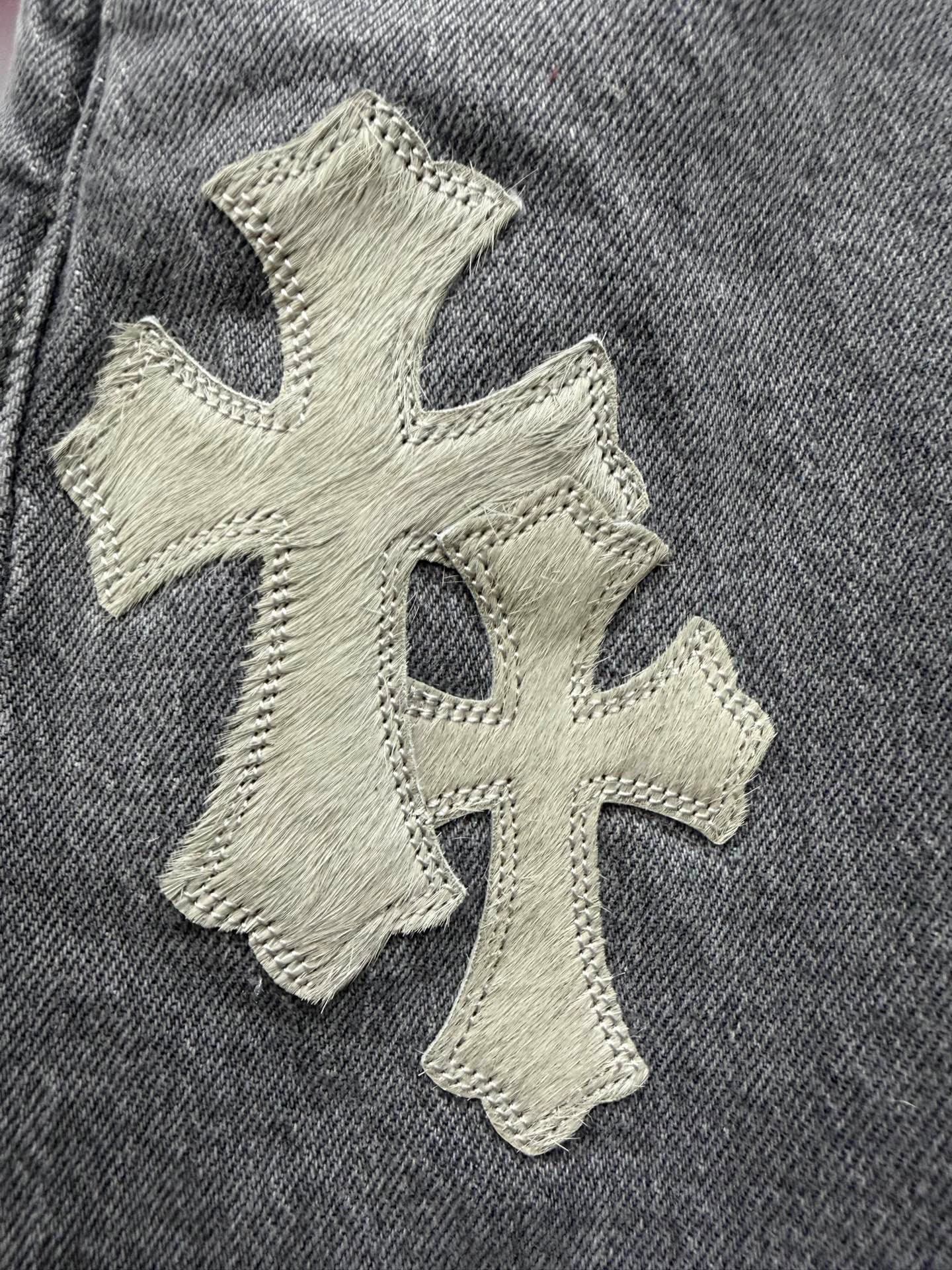 Крупный план кожаной нашивки в виде креста на джинсах Chrome Hearts x Levi's 501
