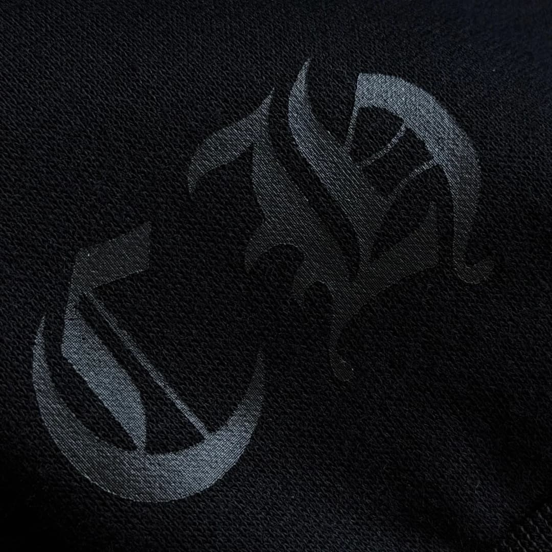 Чёрный готический логотип на кармане худи в тон ткани крупным планом