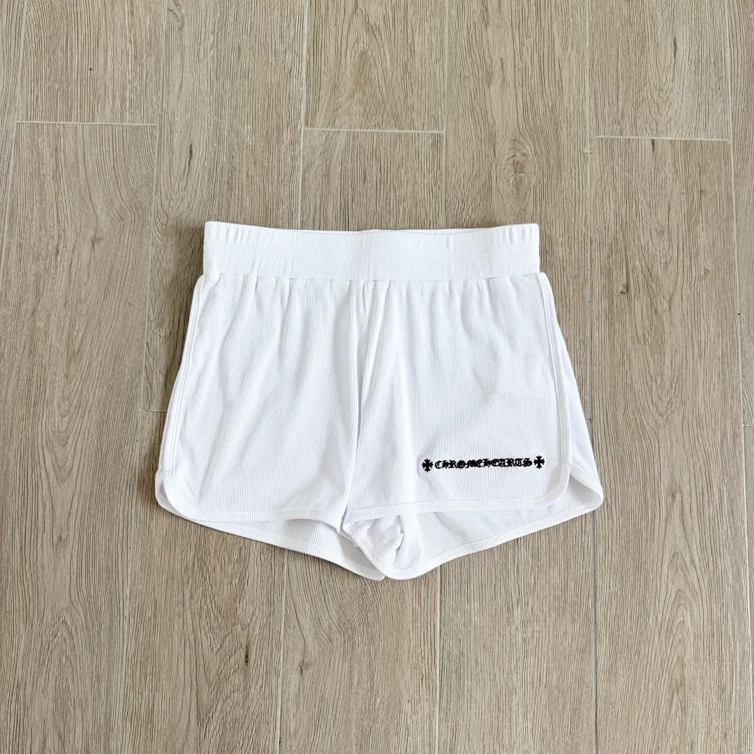 Белые короткие трикотажные шорты Chrome Hearts, вид спереди на деревянном полу