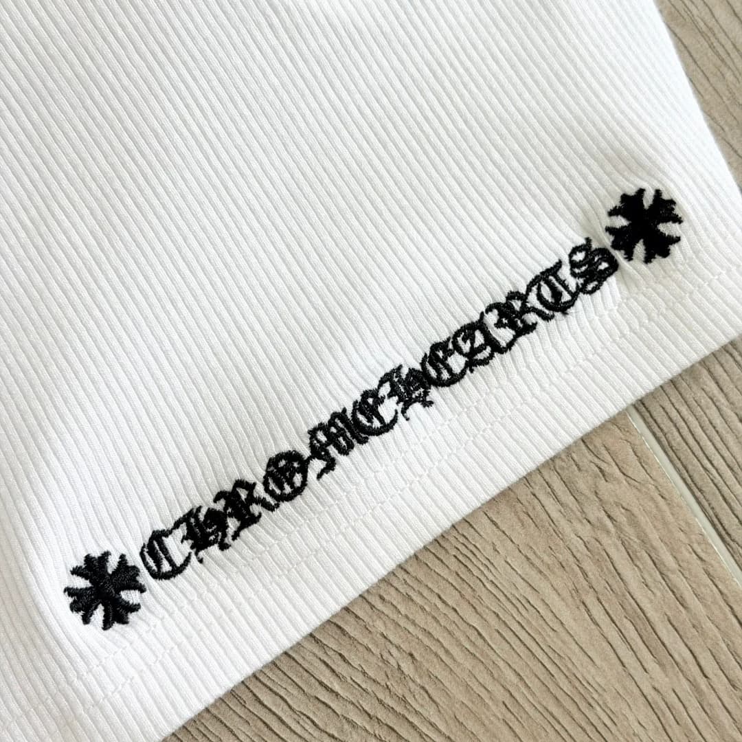 Крупный план чёрной вышивки с названием бренда на белой ребристой ткани