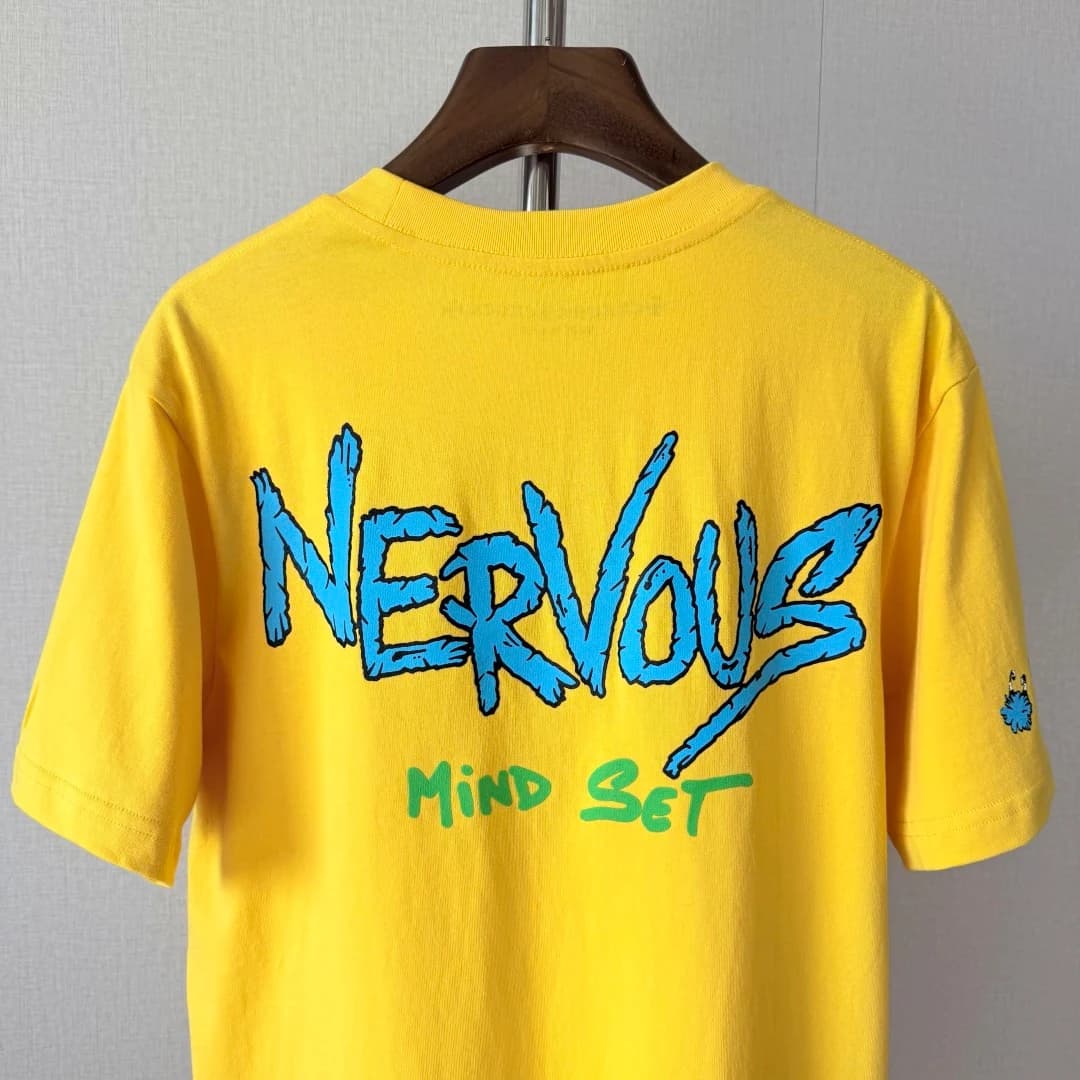 Спинка жёлтой футболки на вешалке с принтом Nervous Mind Set
