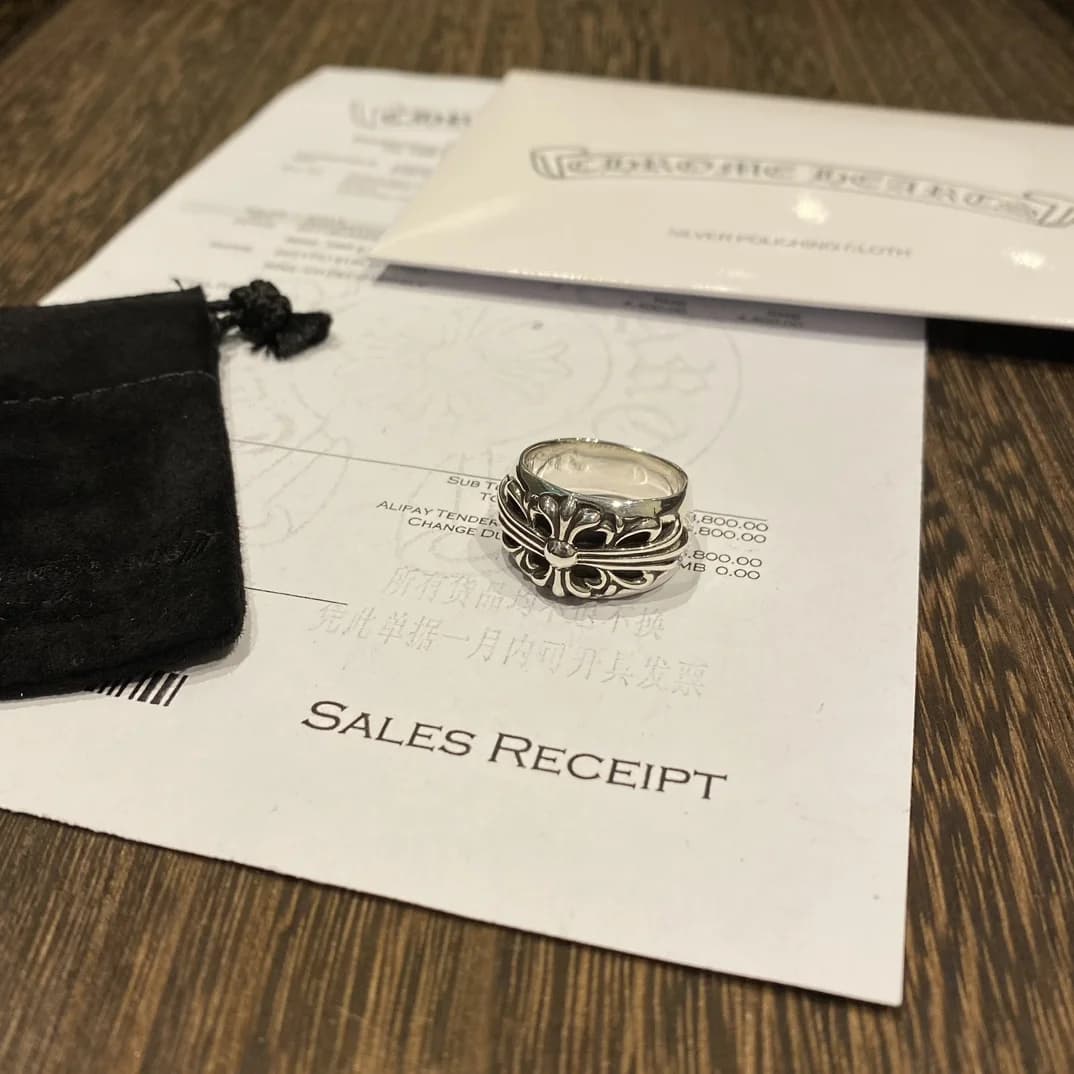 Серебряное кольцо Chrome Hearts на фоне фирменного чека, салфетки и мешочка