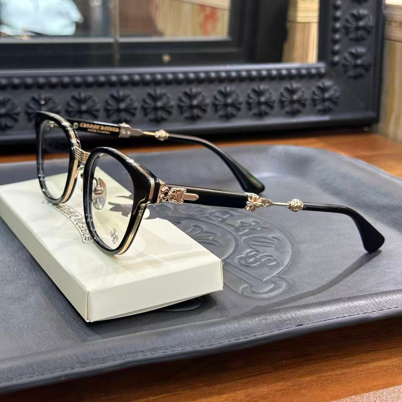 Очки Chrome Hearts Duck Butter Black Gold на белой подставке, вид сбоку