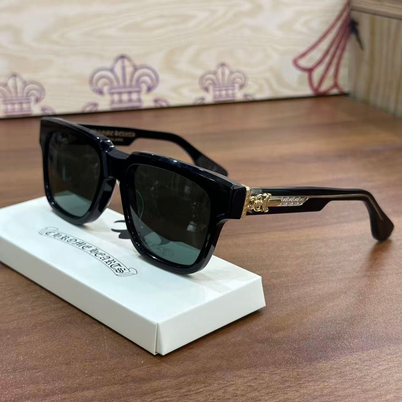 Черные солнцезащитные очки Chrome Hearts BOX-OFFICER с золотистыми деталями, вид спереди три четверти