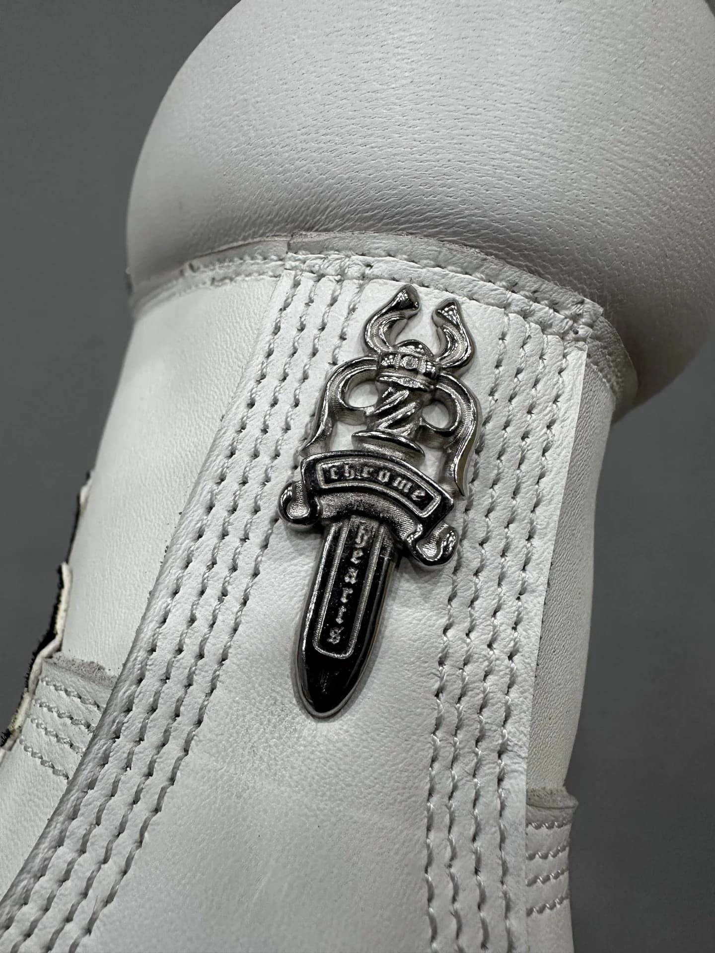 Крупный план металлической детали Dagger на заднике ботинок Chrome Hearts x Timberland