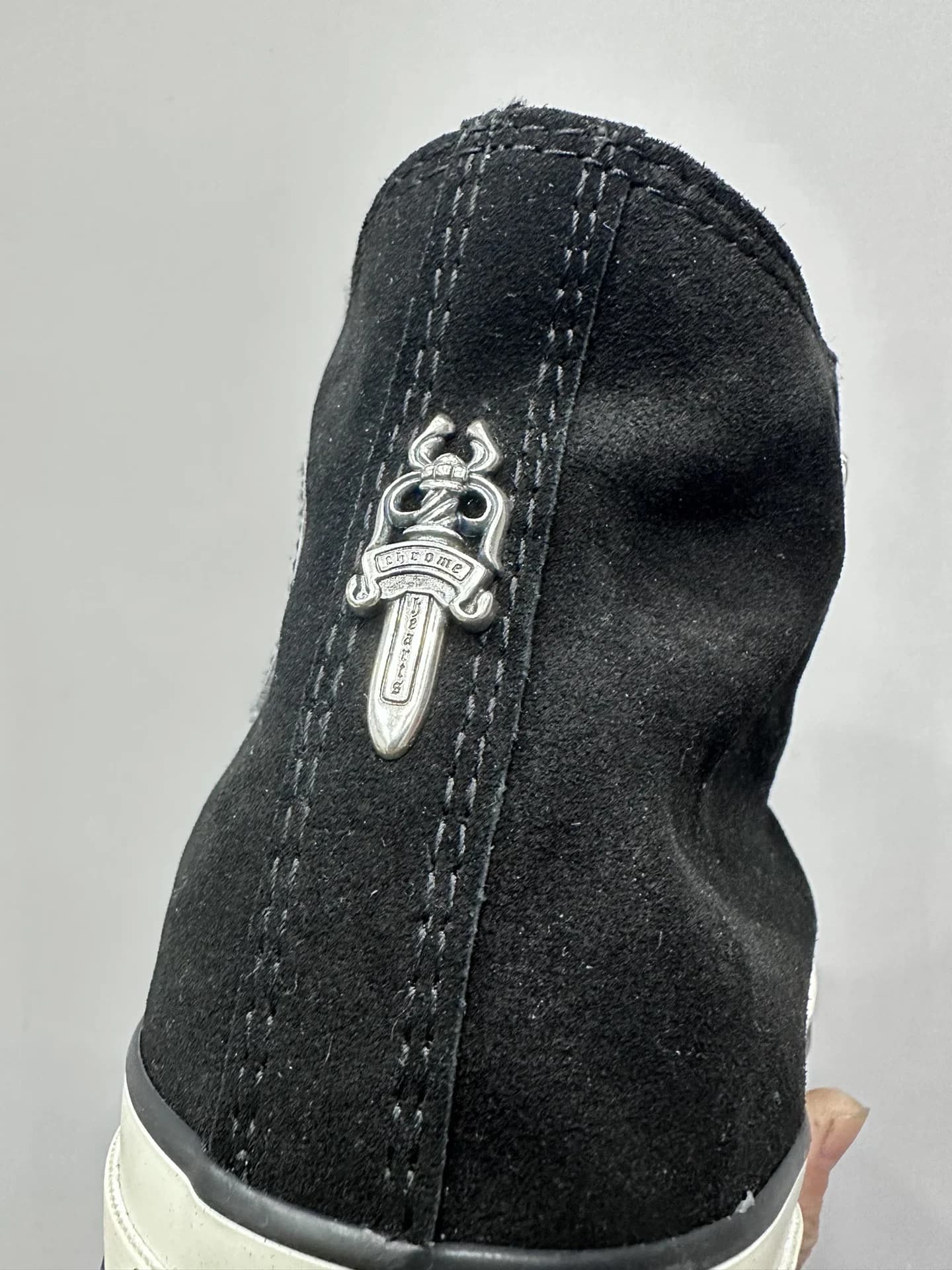 Крупный план серебряного кинжала на заднике кед Chrome Hearts x Converse Chuck 70