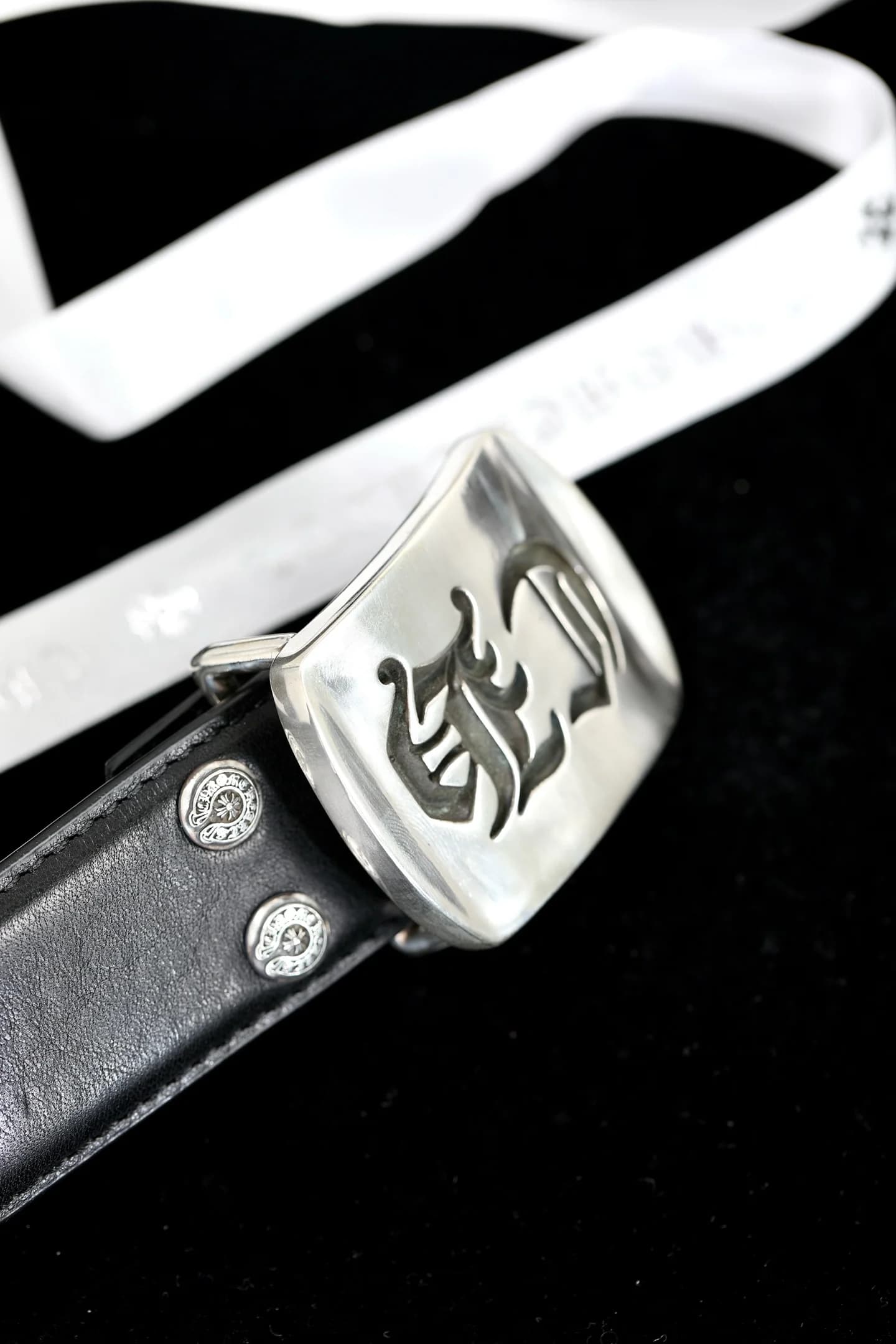 Серебряная пряжка с гравировкой и заклепками на черном кожаном ремне Chrome Hearts