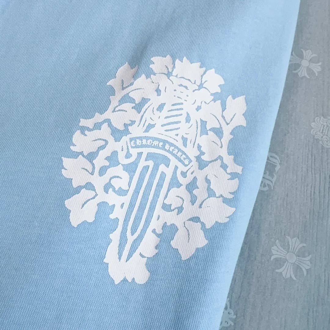 Деталь принта с кинжалом на голубом лонгсливе Chrome Hearts