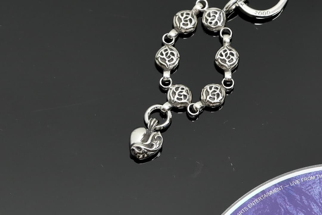 Детали резных звеньев и подвески-сердца серебряного кулона Chrome Hearts крупным планом