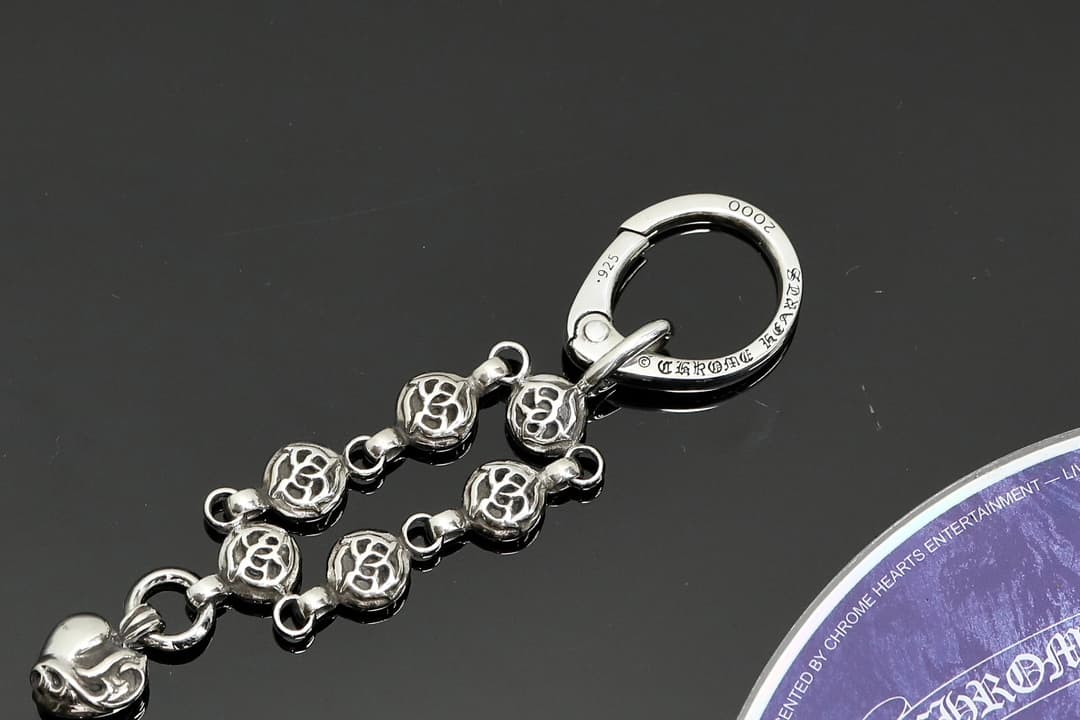 Крупный план круглого карабина с гравировкой и звеньев кулона Chrome Hearts