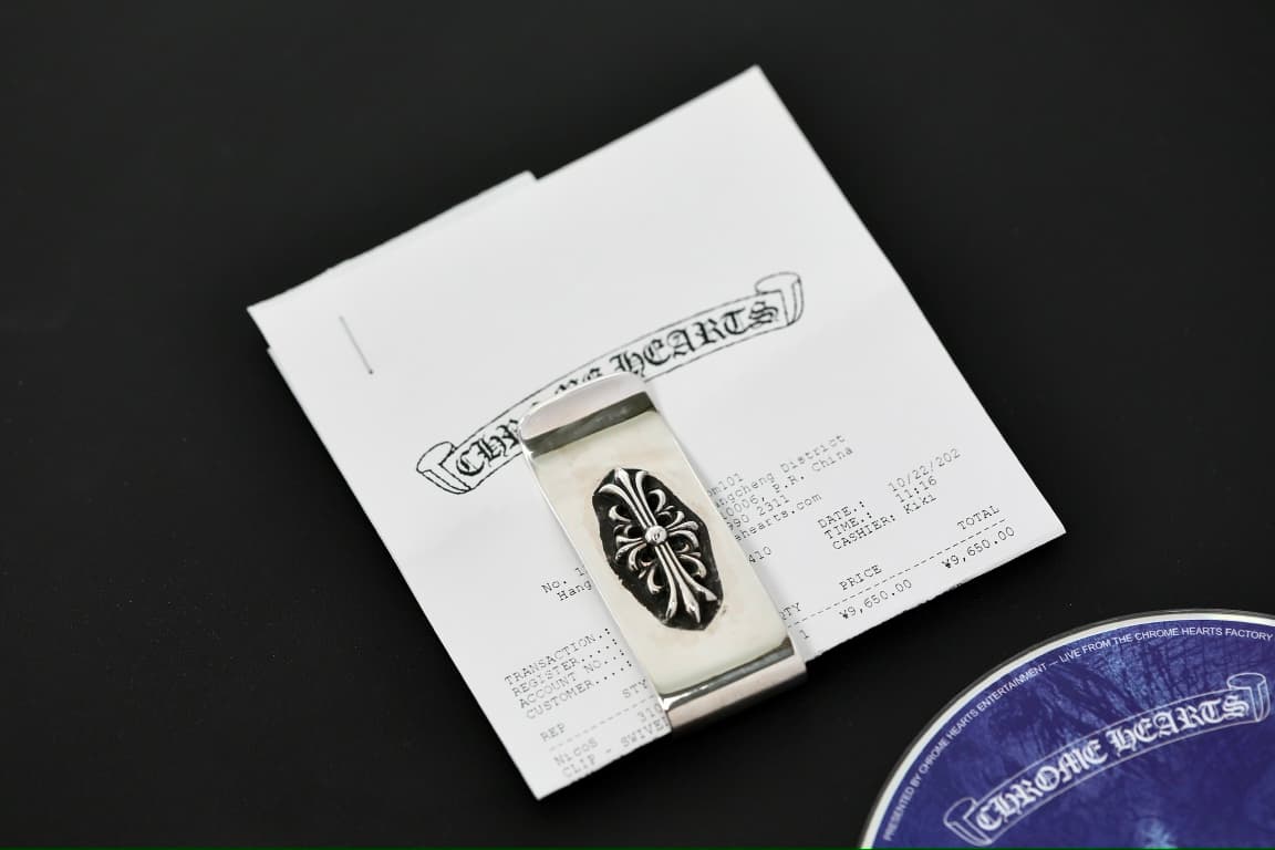 Зажим для денег Chrome Hearts на фоне фирменного чека