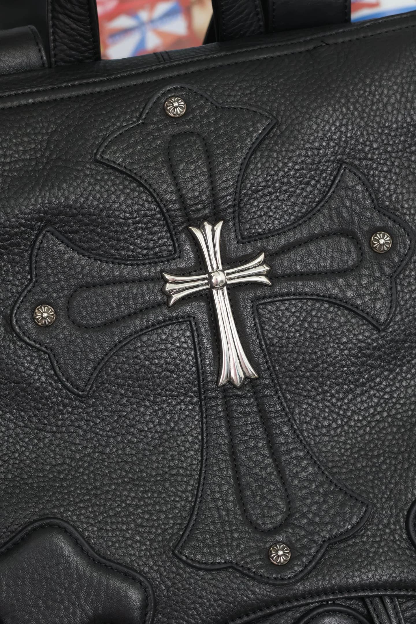 Фрагмент с серебряным крестом и заклепками на кожаном клапане Chrome Hearts