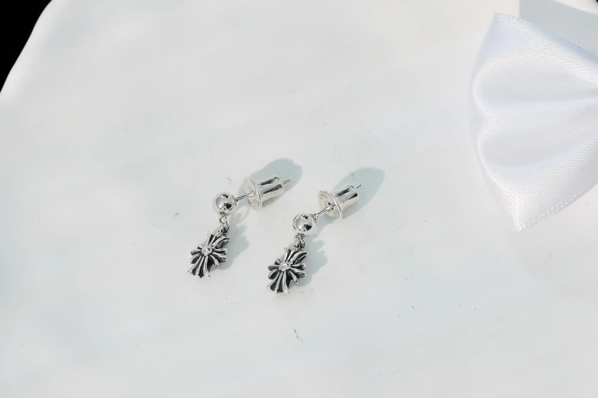 Серьги-гвоздики Chrome Hearts с подвесками-крестами на белом фоне