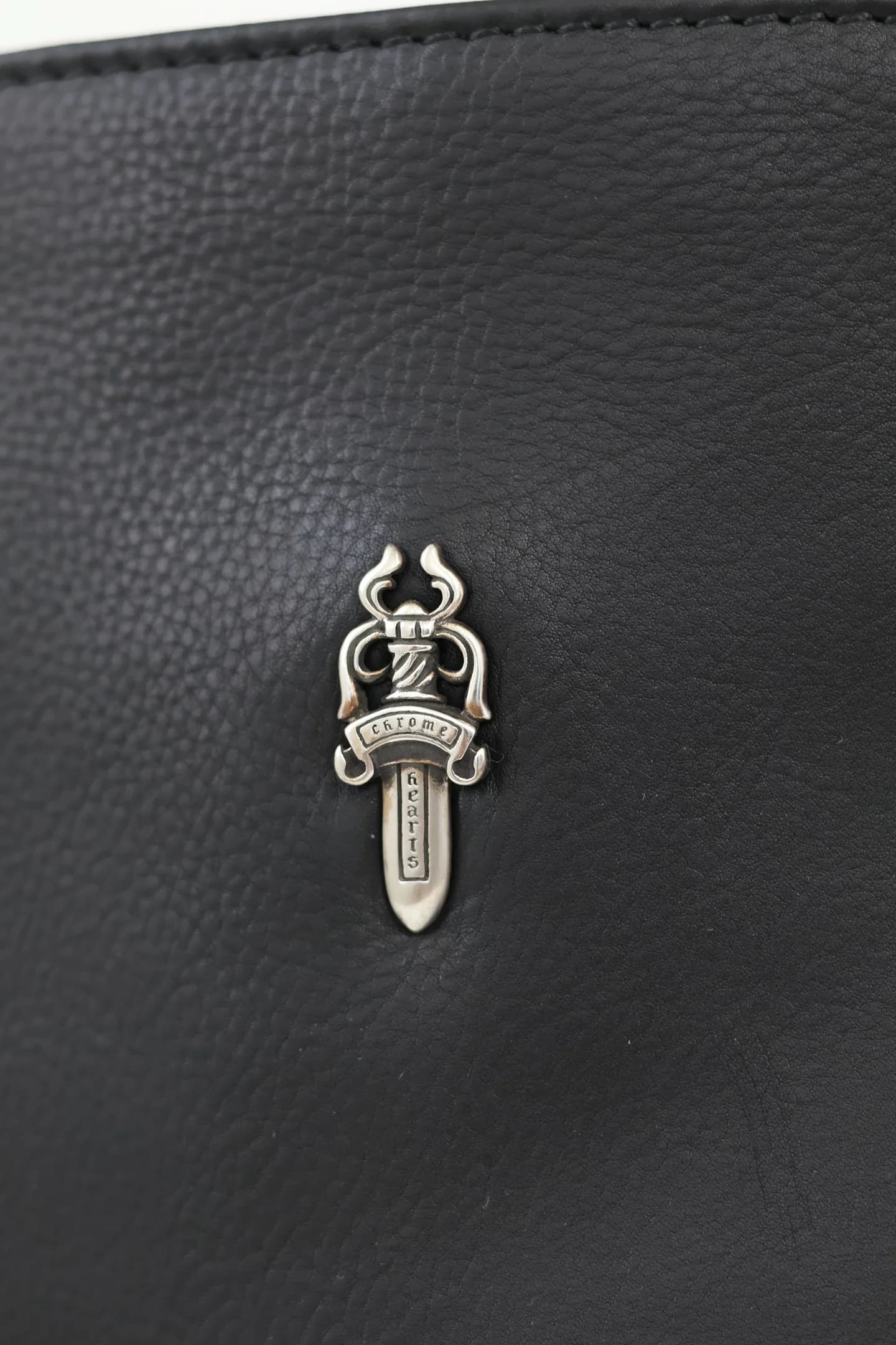 Макрофотография серебряного кинжала Dagger 925 пробы на коже