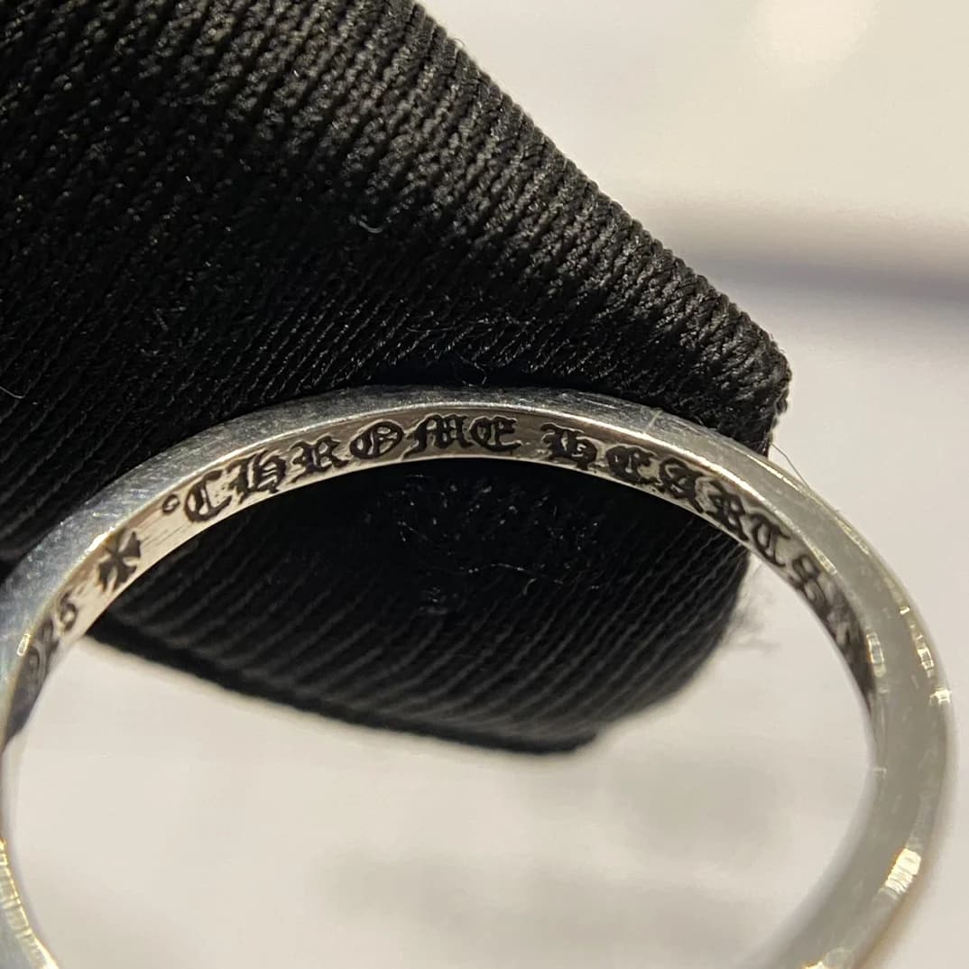 Крупный план фирменной гравировки Chrome Hearts внутри кольца