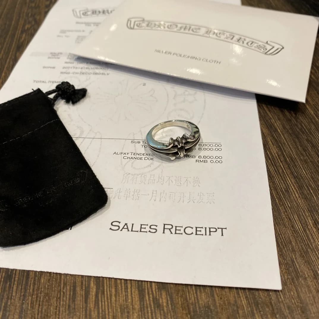 Общий вид серебряного кольца Chrome Hearts на фоне документов