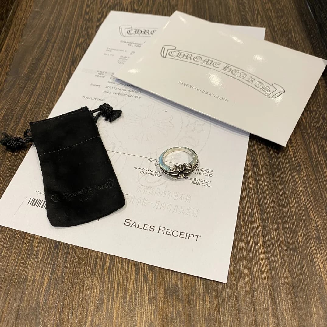 Вид сверху на серебряное кольцо Chrome Hearts и упаковочные аксессуары