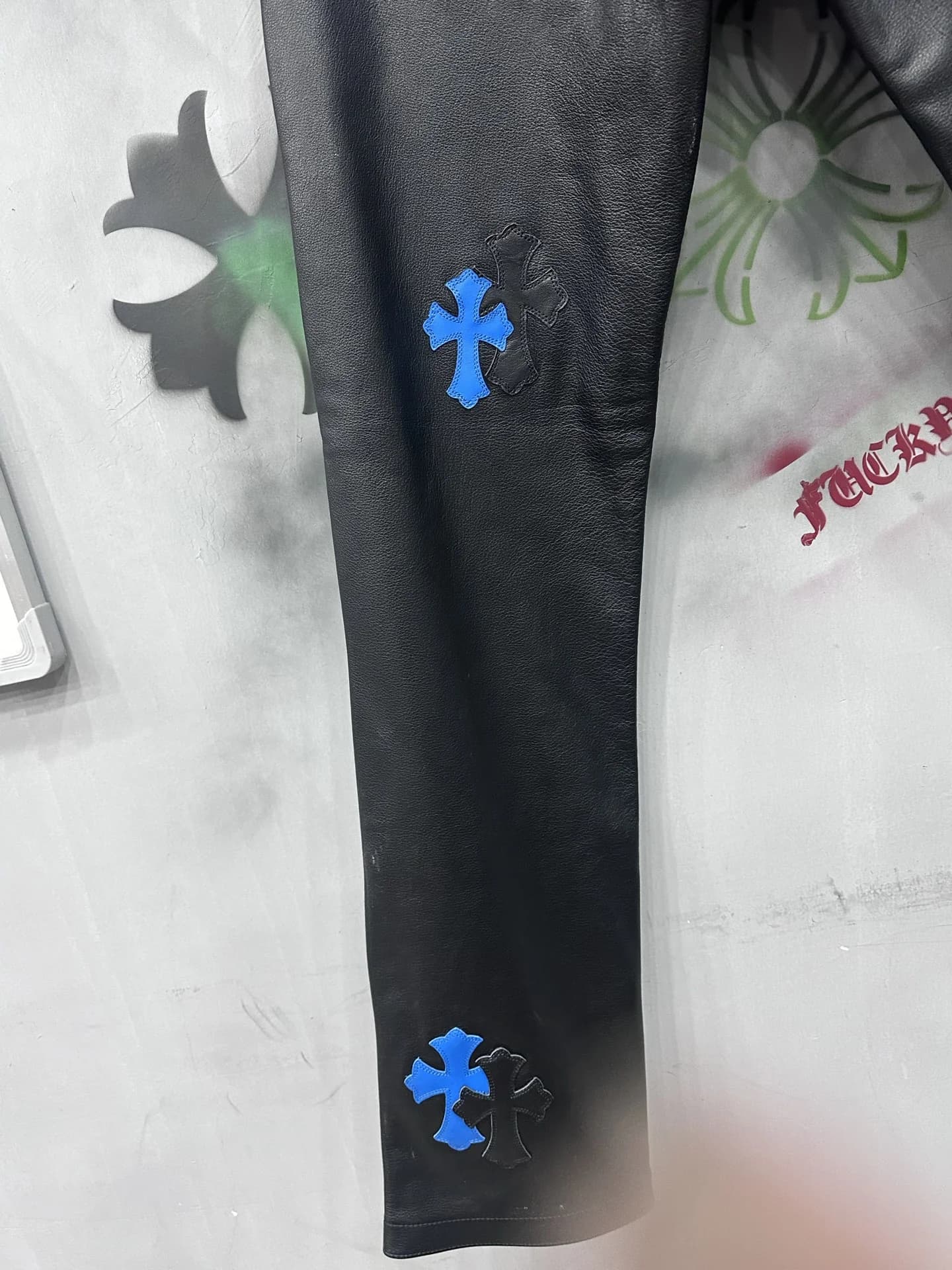 Нижняя часть брючины черных кожаных брюк Chrome Hearts с нашивками